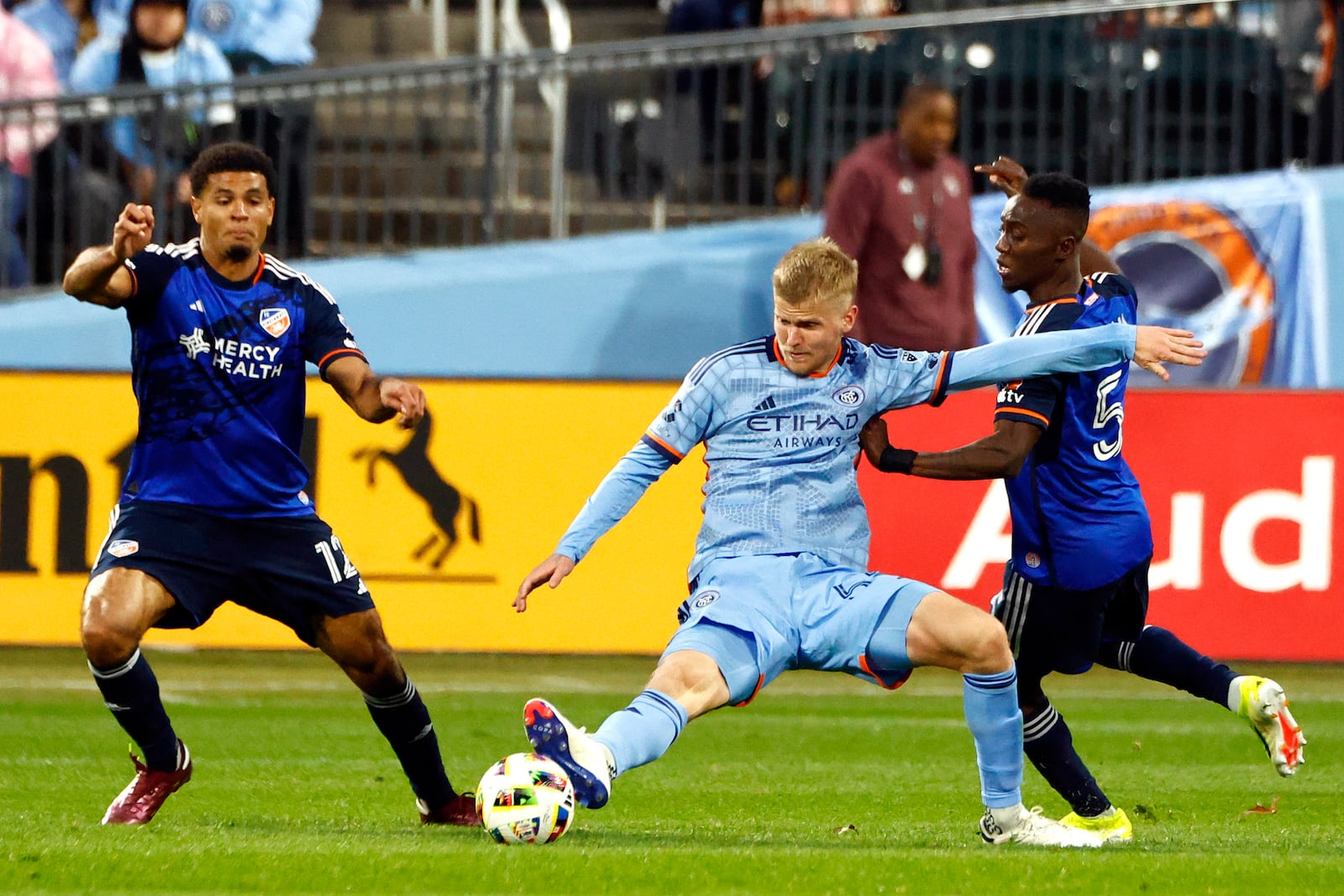 New York City FC Keaton Parks (55) fights for the ball with FC Cincinnati's Miles Robinson (12) and Obinna Nwobodo (5) during Game 2 in the first round of the MLS Cup soccer playoffs, Saturday, Nov. 2, 2024, in New York. (AP Photo/Kena Betancur)