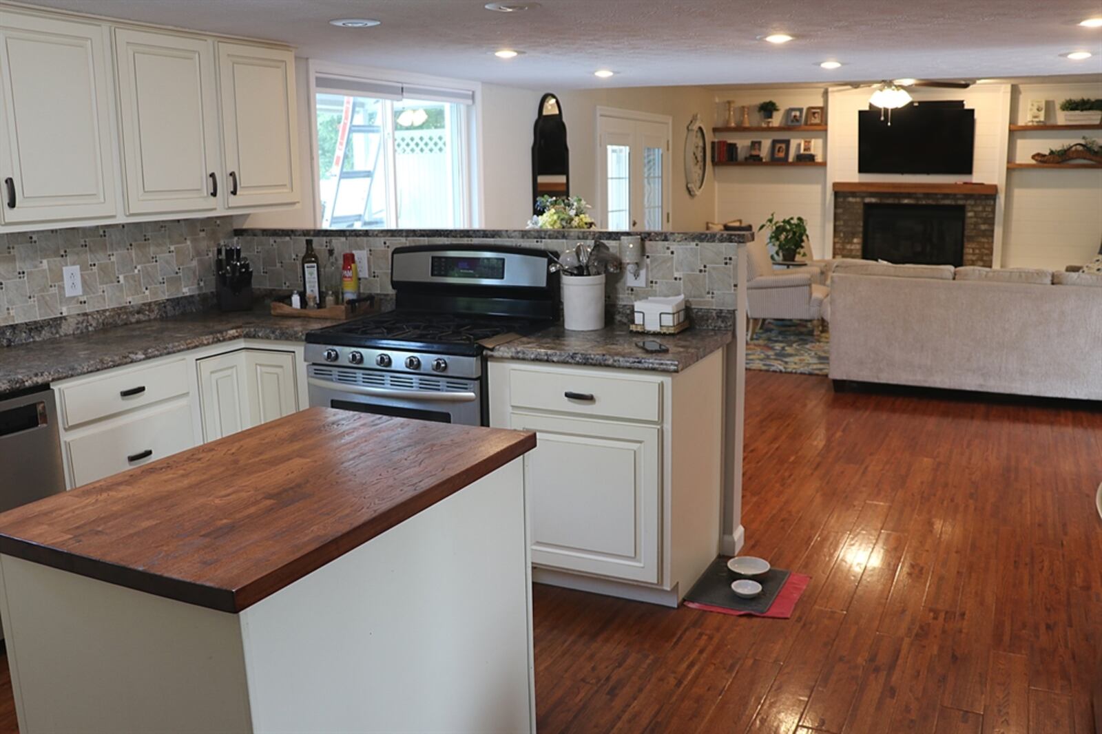 The kitchen at 4141 Abbeygate Drive has antiqued white cabinetry that complements the countertops, and detailed ceramic tile backsplash that pulls in the decorative design. CONTRIBUTED