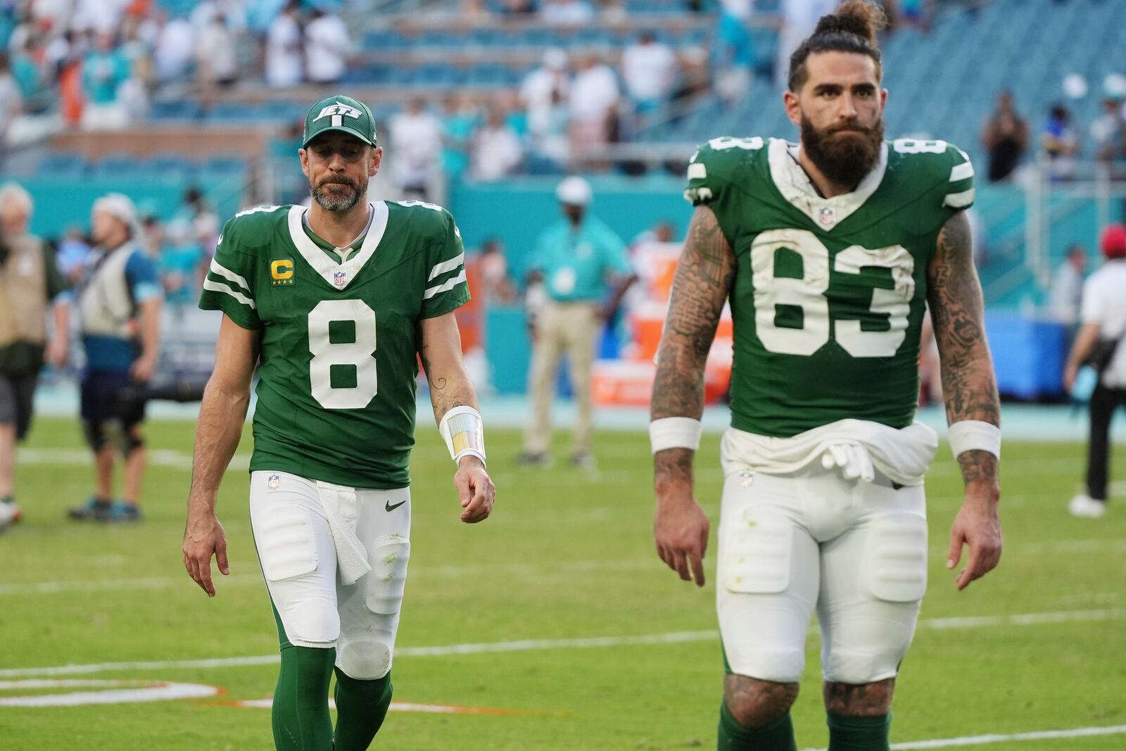 New York Jets quarterback Aaron Rodgers (8) and tight end Tyler Conklin (83) leave the field at the end an NFL football game against the Miami Dolphins, Sunday, Dec. 8, 2024, in Miami Gardens, Fla. (AP Photo/Lynne Sladky)