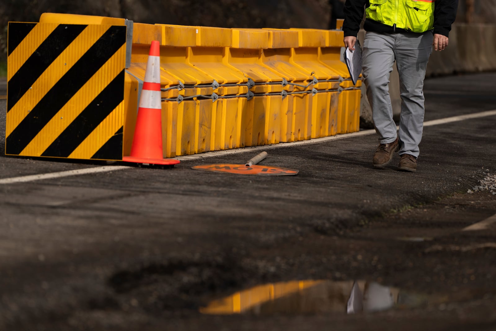 A worker walks by a safety barrier as construction continues on Stark Street Bridge on Thursday, Feb. 6, 2025, in Troutdale, Ore. (AP Photo/Jenny Kane)