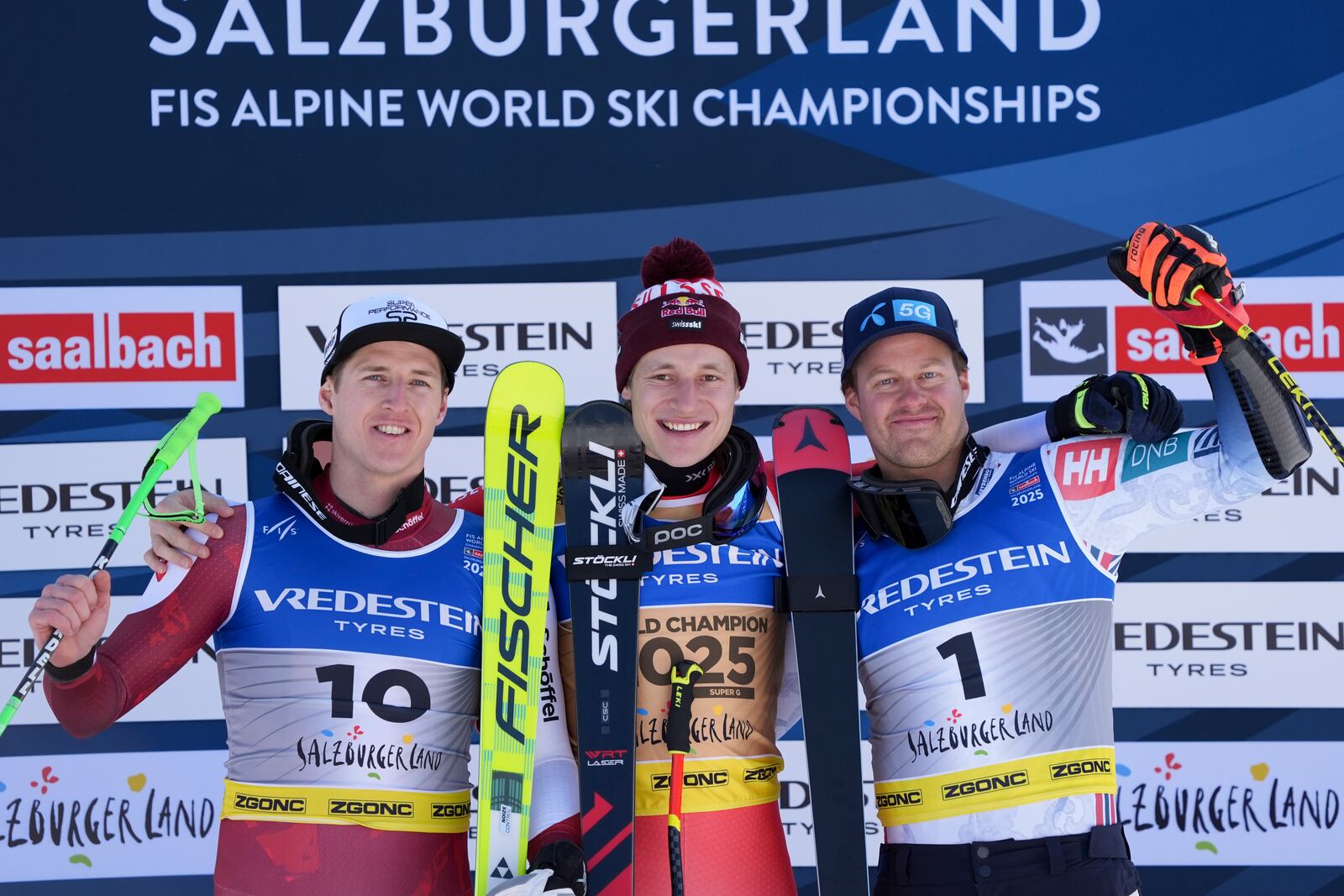 Switzerland's Marco Odermatt, gold medal winner of a men's Super-G, celebrates on the podium with second-placed silver medalist Austria's Raphael Haaser, left, and third-placed bronze medalist Norway's Adrian Smiseth Sejersted, at the Alpine Ski World Championships, in Saalbach-Hinterglemm, Austria, Friday, Feb. 7, 2025. (AP Photo/Giovanni Auletta)