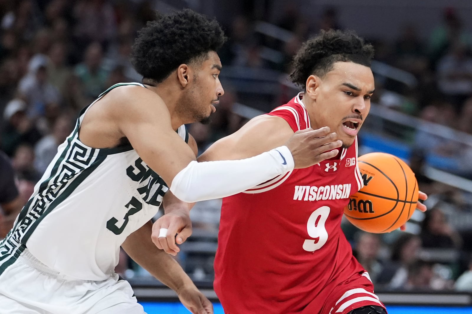 Wisconsin guard John Tonje (9) drives on Michigan State guard Jaden Akins (3) during the second half of an NCAA college basketball game in the semifinals of the Big Ten Conference tournament in Indianapolis, Saturday, March 15, 2025. (AP Photo/Michael Conroy)