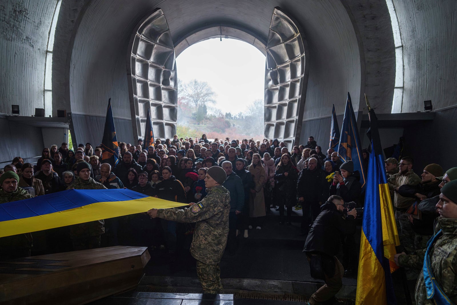 Honour Guard hold the national flag above the coffin of fallen Ukrainian serviceman of 3rd assault brigade Danylo Liashkevych, known as "Berserk", who was killed together with his girlfriend Valentyna Nagorna, known as "Valkiria", during the funeral ceremony at a crematorium in Kyiv, Ukraine, Friday Nov. 8, 2024. (AP Photo/Evgeniy Maloletka)