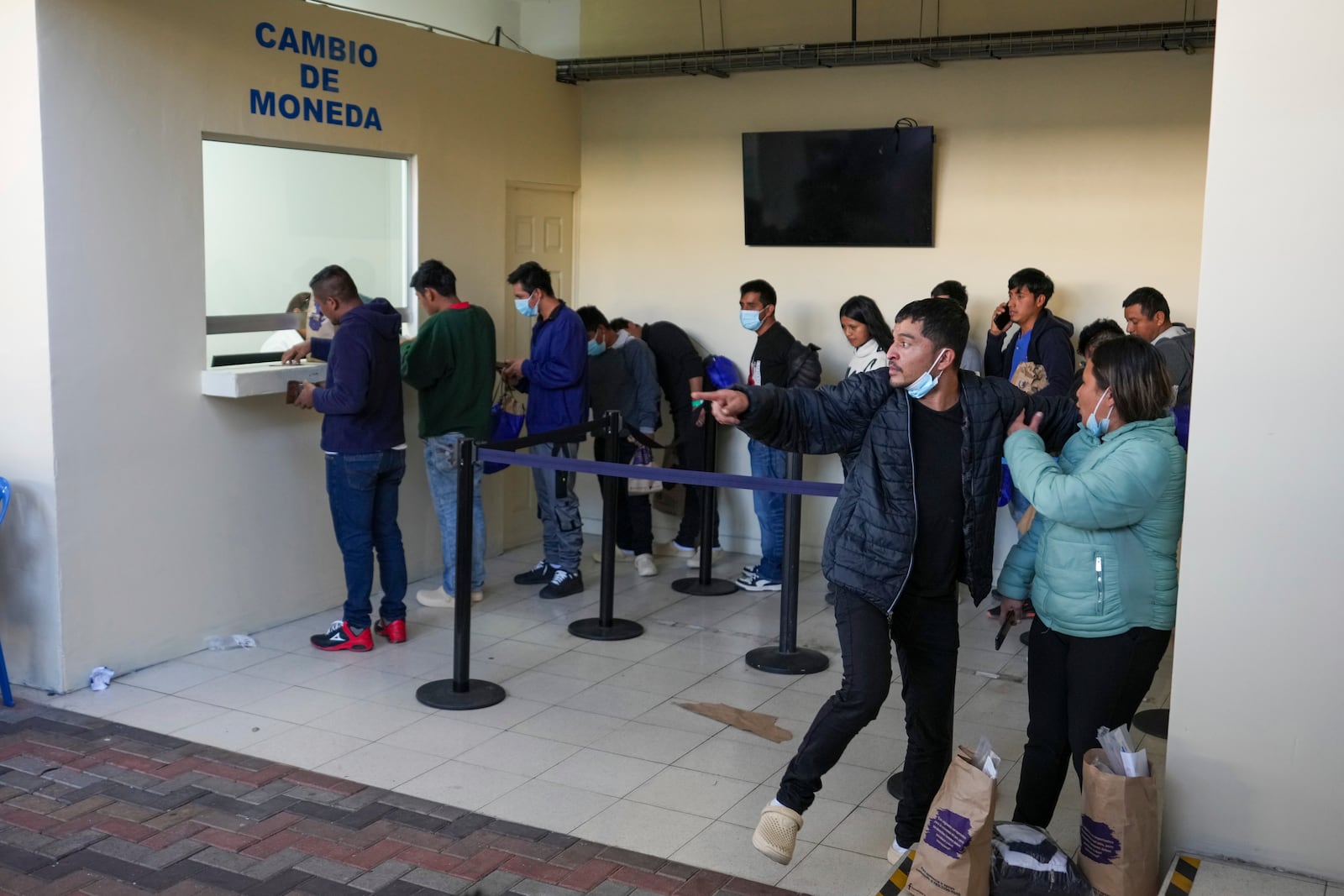 Guatemalan migrants wait to exchange money after being deported from the United States, at La Aurora airport in Guatemala City, Monday, Jan. 27, 2025. (AP Photo/Moises Castillo)