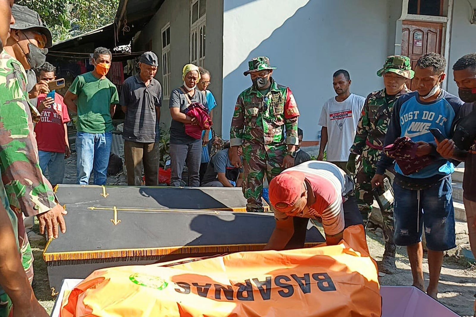 Indonesian soldiers and residents put the body of a victim into a coffin for burial following the eruption of Mount Lewotobi Laki-Laki in East Flores, Indonesia, Monday, Nov. 4, 2024. (AP Photo)