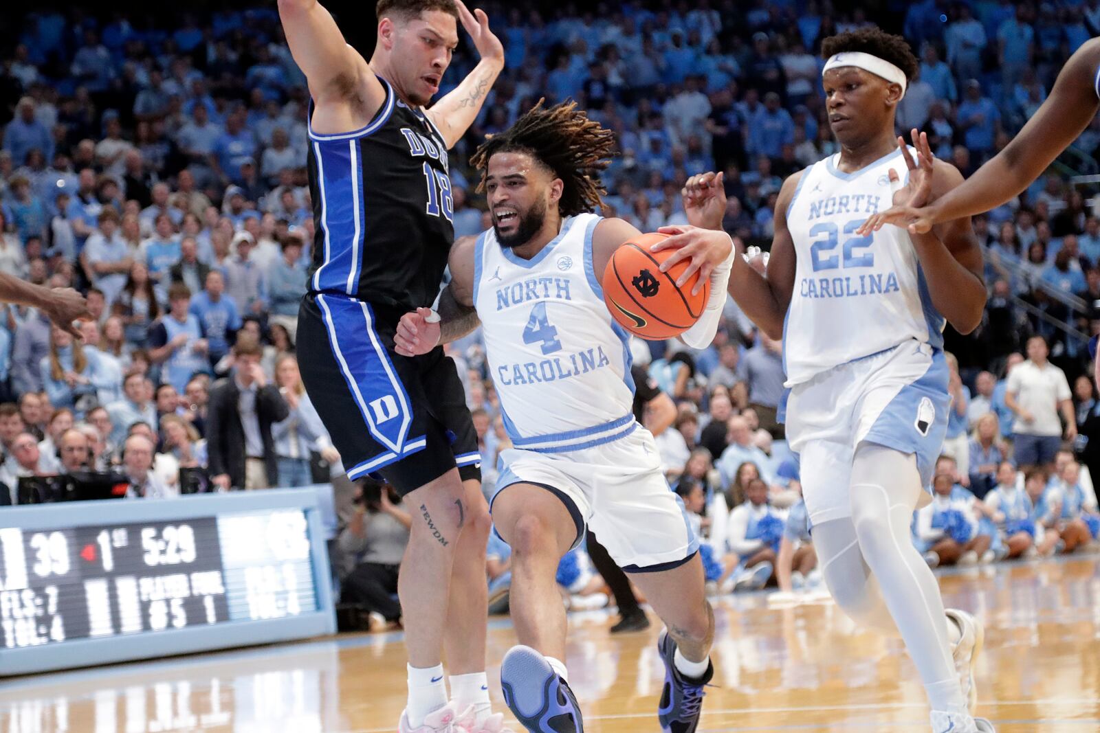 North Carolina guard RJ Davis (4) drives against Duke forward Mason Gillis (18) during the first half of an NCAA college basketball game Saturday, March 8, 2025, in Chapel Hill, N.C. North Carolina forward Ven-Allen Lubin (22) trails at right. (AP Photo/Chris Seward)