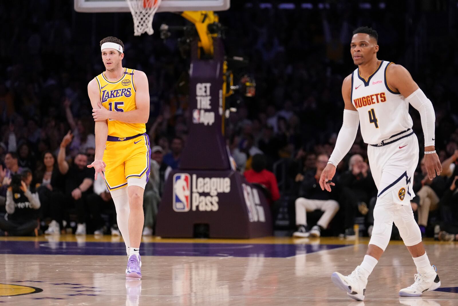 Los Angeles Lakers guard Austin Reaves, left, gestures after scoring as Denver Nuggets guard Russell Westbrook stands by during the first half of an NBA basketball game Wednesday, March 19, 2025, in Los Angeles. (AP Photo/Mark J. Terrill)