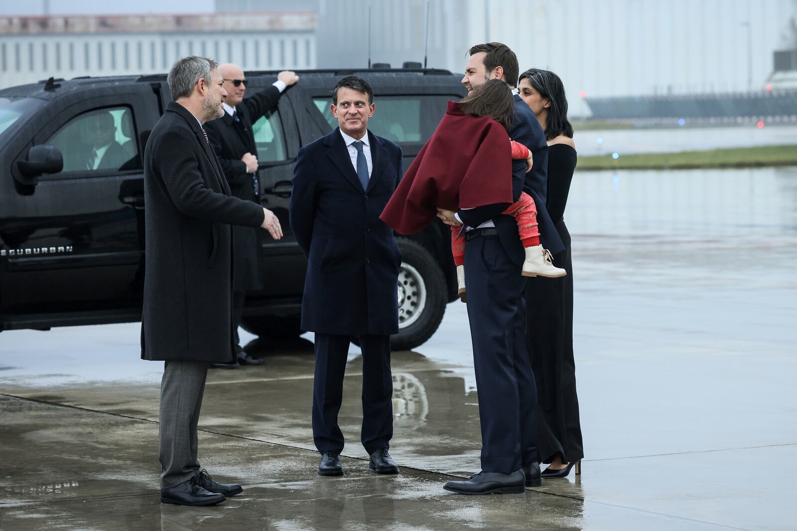 United States Vice-President JD Vance, second right, carries his daughter Mirabel as he arrives at Paris Orly Airport with second lady Usha Vance, and is greeted by Manuel Valls, the minister for Overseas France, and the U.S. embassy's charge d'affaires , David McCawley, ahead of an Artificial Intelligence Action Summit taking place in Paris, Monday, Feb. 10, 2025. (AP Photo/Thomas Padilla)