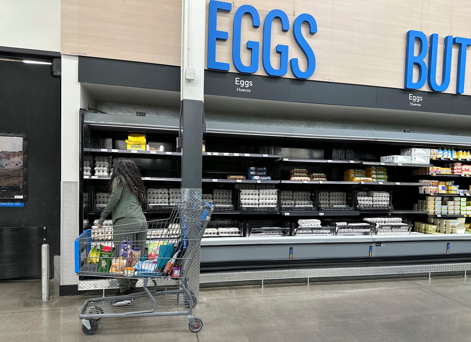 A shopper selects a carton of eggs from a display in a Walmart store Friday, Feb. 7, 2025, in Englewood, Colo. (AP Photo/David Zalubowski)