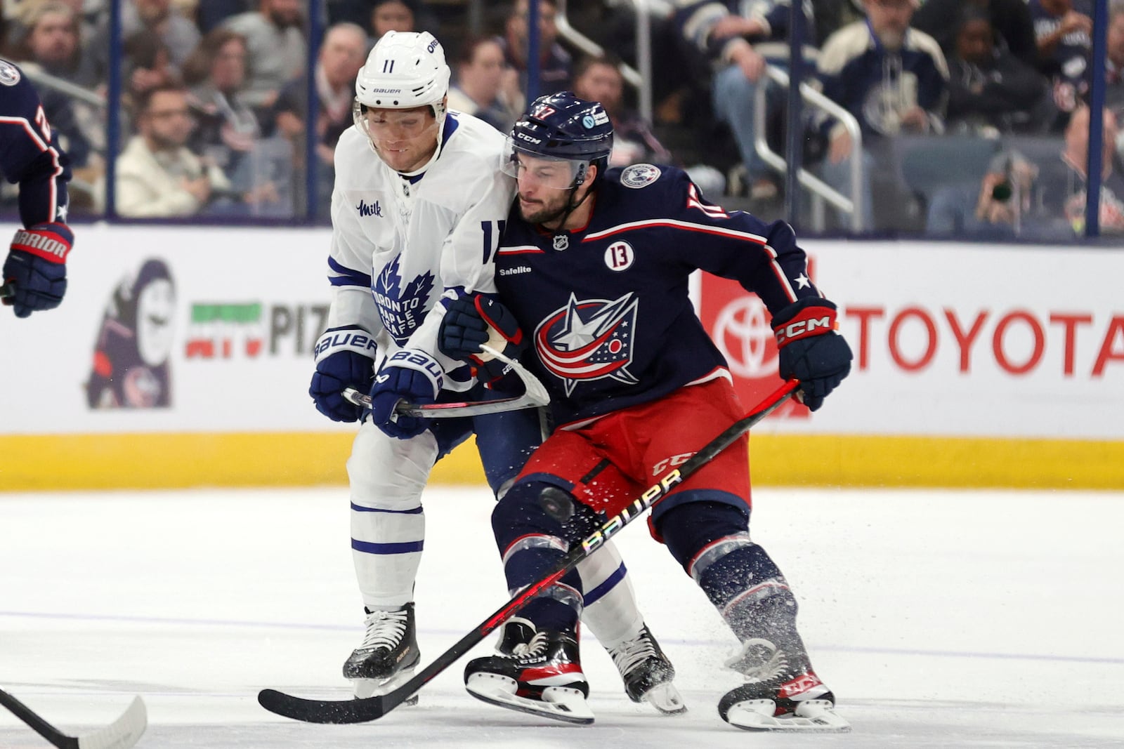 Columbus Blue Jackets forward Justin Danforth, right, checks Toronto Maple Leafs forward Max Domi during the first period of an NHL hockey game in Columbus, Ohio, Tuesday, Oct. 22, 2024. (AP Photo/Paul Vernon)