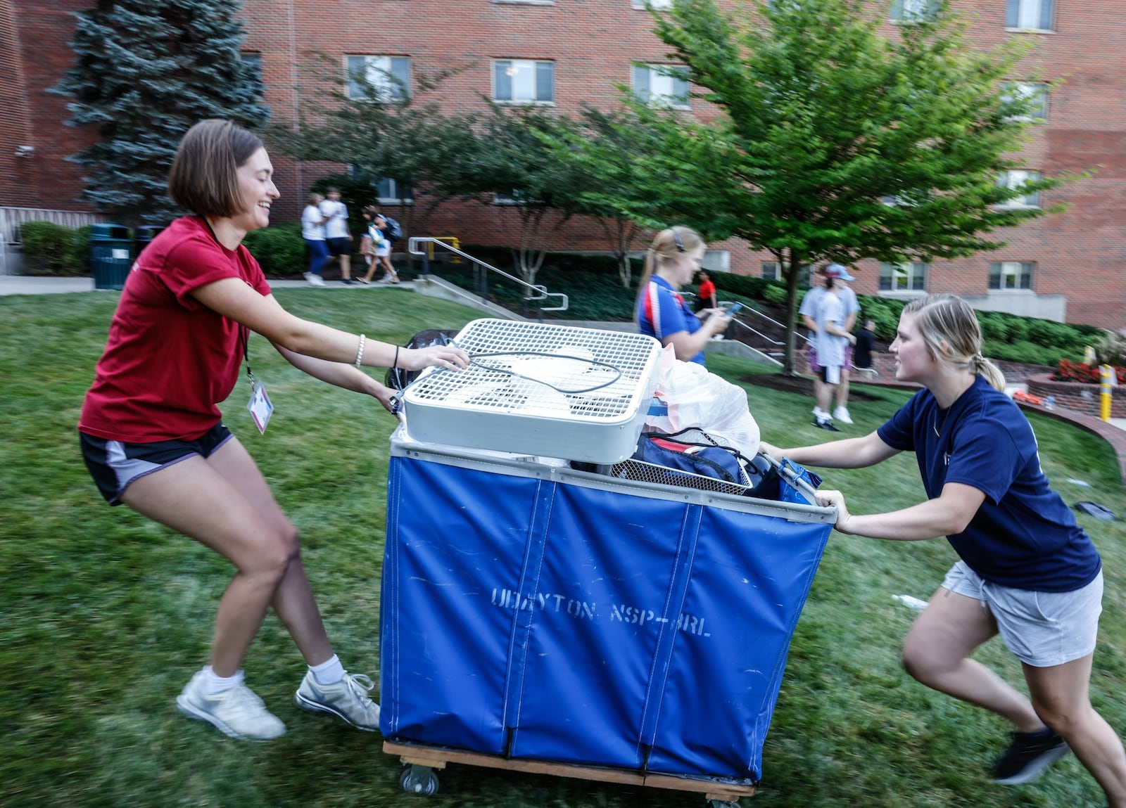 University of Dayton freshmen Landry McVicker, left and Kate Larger push their stuff up the hill to Marycrest Hall. Friday August 19 was "move in" day for 1,800 at the university. JIM NOELKER/STAFF