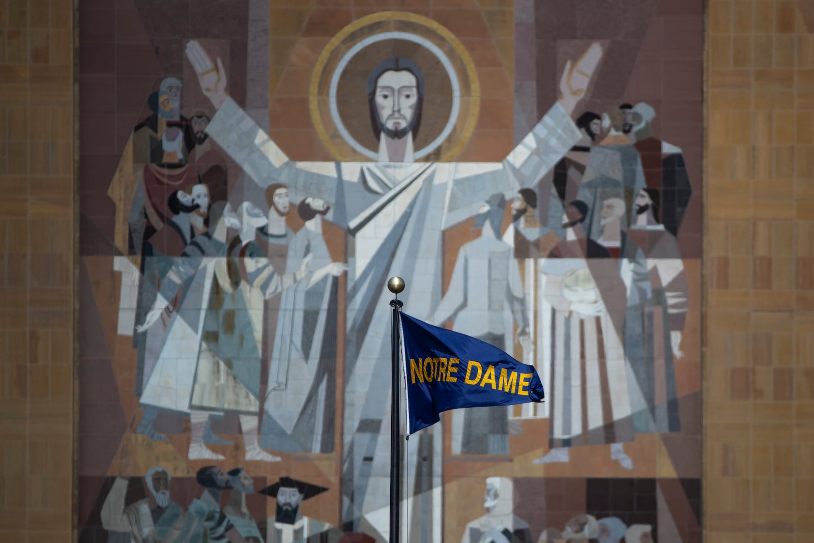 FILE - A Notre Dame flag waves in the wind in front of the The Word of Life Mural, aka "Touchdown Jesus," on the Hesburgh Library before an NCAA college football game between Notre Dame and Northern Illinois, Saturday Sept. 7, 2024, in South Bend, Ind. (AP Photo/Michael Caterina, File)