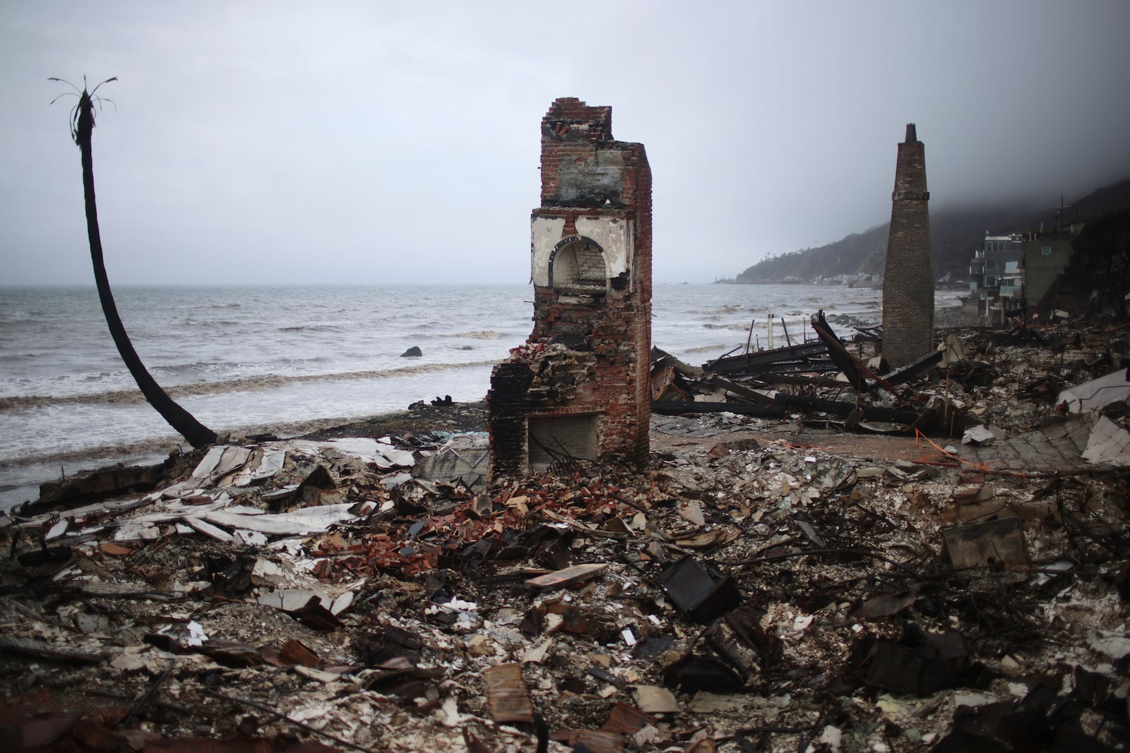 A fire-damaged beachfront property is seen in the Palisades Fire zone during a storm Thursday, Feb. 13, 2025, in Malibu, Calif. (AP Photo/Ethan Swope)