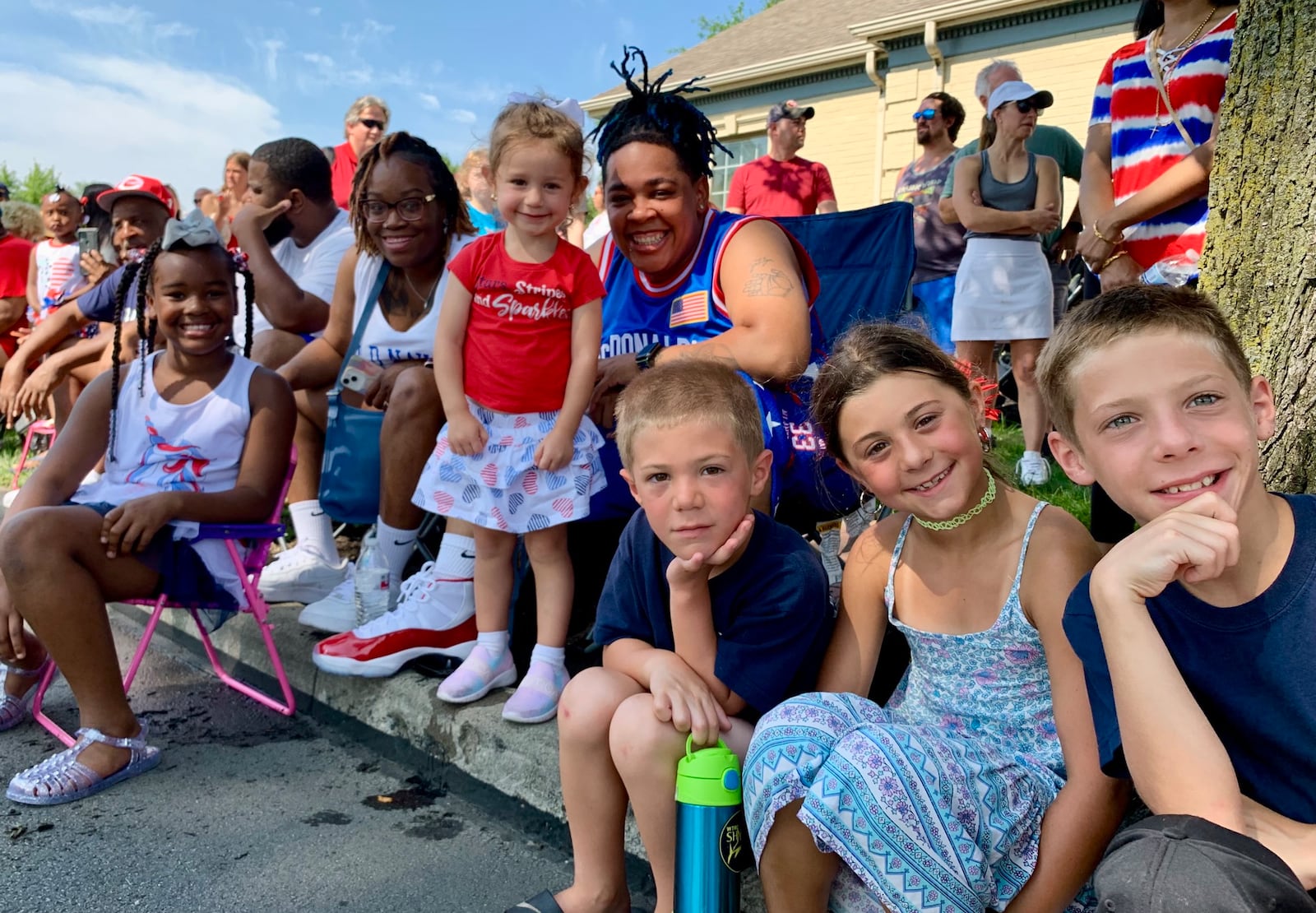 From left to right, back row: Serenity Casey, Ashley Melson, Rose Mazzola, Eboni Melson. Front row: Owen, Clara, and Frank Deaton. All watch the parade at the Americana Festival in Centerville, the morning of July 4, 2023. LONDON BISHOP/STAFF