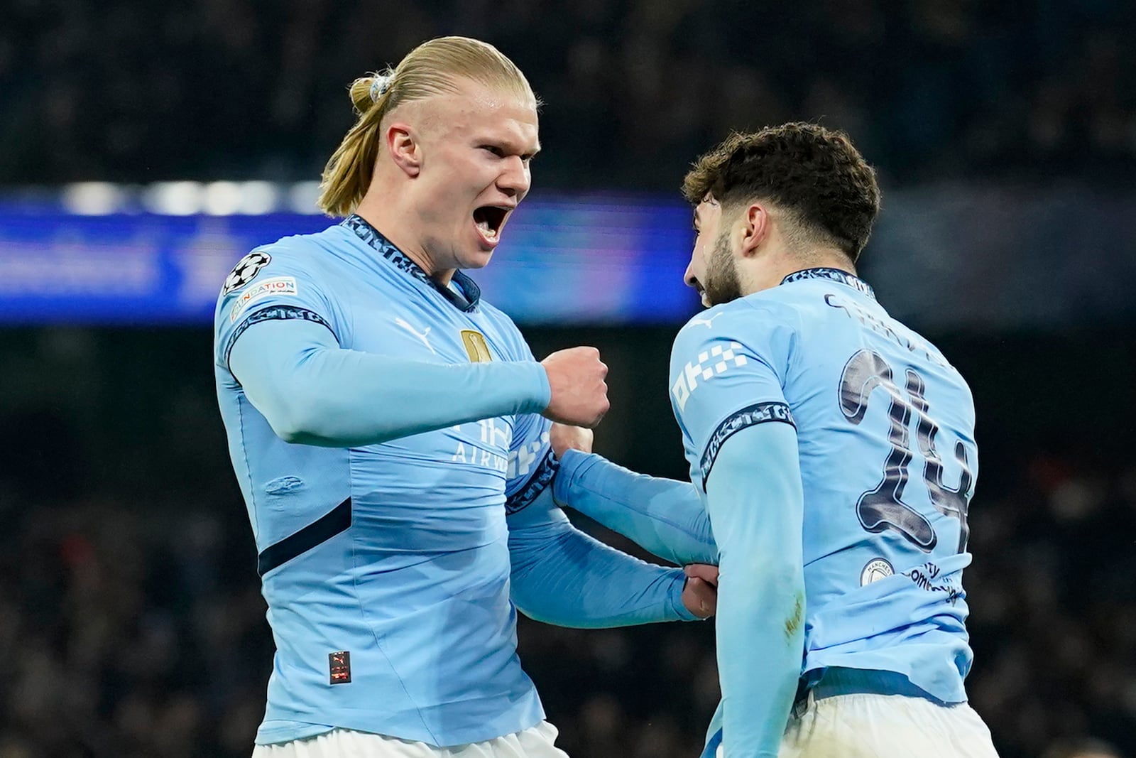 Manchester City's Erling Haaland, left, celebrates with Manchester City's Josko Gvardiol after scoring his sides first goal during the Champions League playoff first leg soccer match between Manchester City and Real Madrid at the Etihad Stadium in Manchester, England, Tuesday, Feb. 11, 2025. (AP Photo/Dave Thompson)