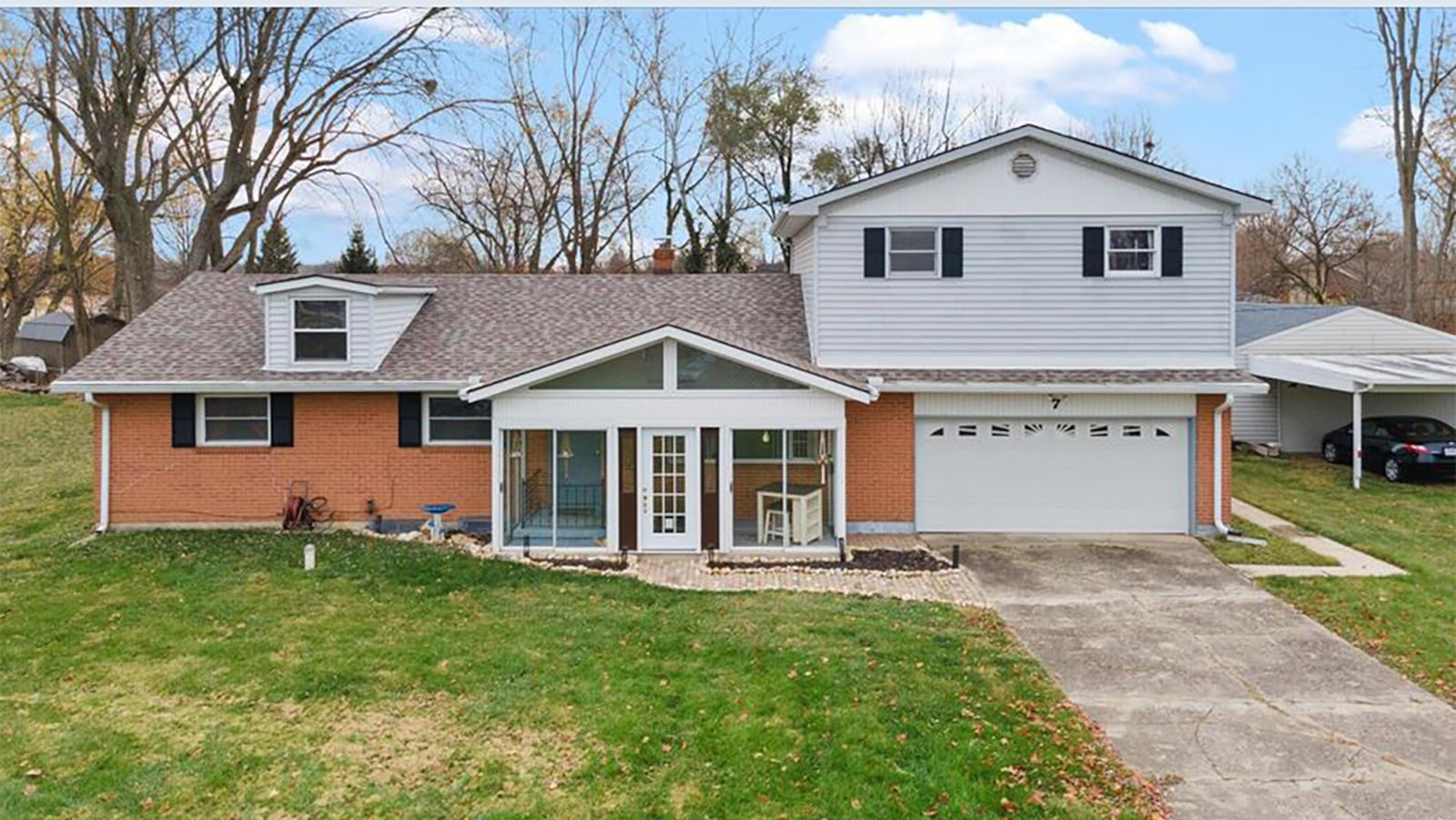 The front of the home features a fully enclosed front porch and two-car attached garage.