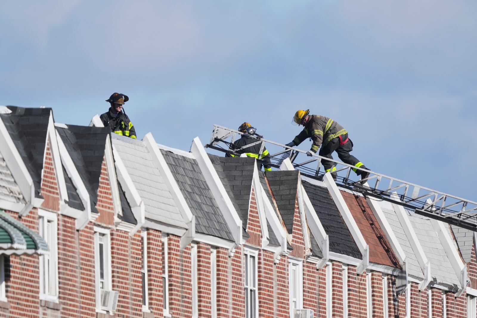 Firefighters climb up on the roof near the scene after a small plane crashed in Philadelphia, Saturday, Feb. 1, 2025. (AP Photo/Matt Rourke)