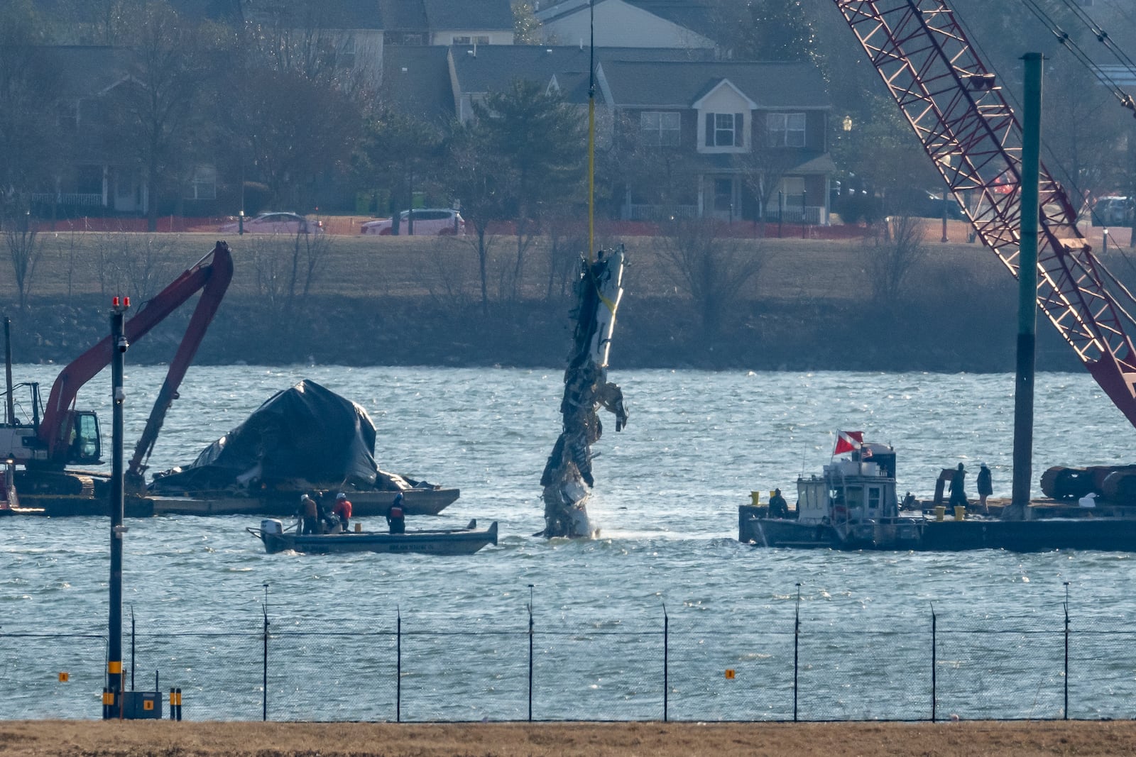 A piece of wreckage is lifted from the water onto a salvage vessel near the site in the Potomac River of a mid-air collision between an American Airlines jet and a Black Hawk helicopter, at Ronald Reagan Washington National Airport, Tuesday, Feb. 4, 2025, in Arlington, Va. (AP Photo/Ben Curtis)