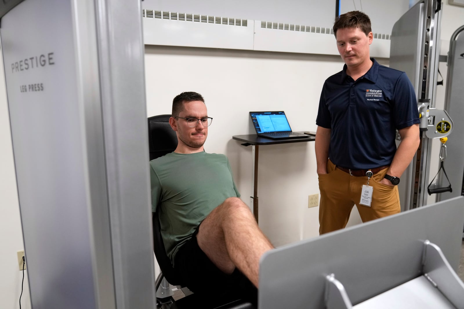 Physical therapist Tyler Detmer, right, watches as patient Jacob Bullard uses a leg press machine at WashU, Monday, Dec. 16, 2024, in St. Louis. (AP Photo/Jeff Roberson)