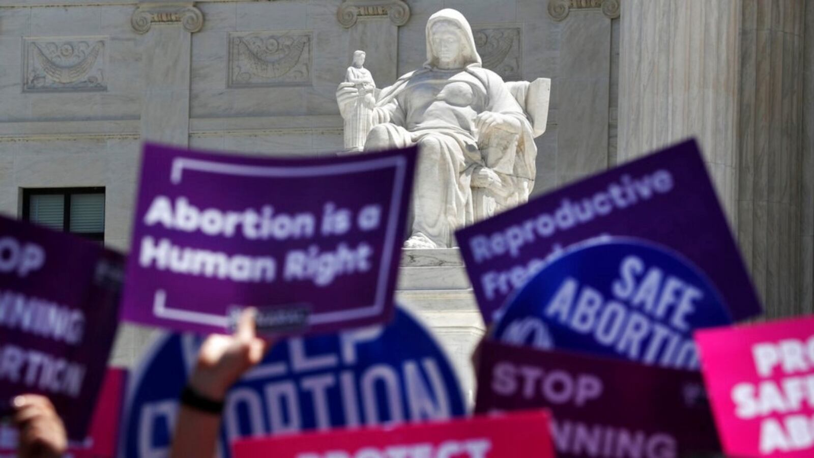 People hold up signs in favor of legal abortion during a protest against abortion bans, Tuesday, May 21, 2019, outside the Supreme Court in Washington. A coalition of dozens of groups held a National Day of Action to Stop the Bans, with other events planned throughout the week.  