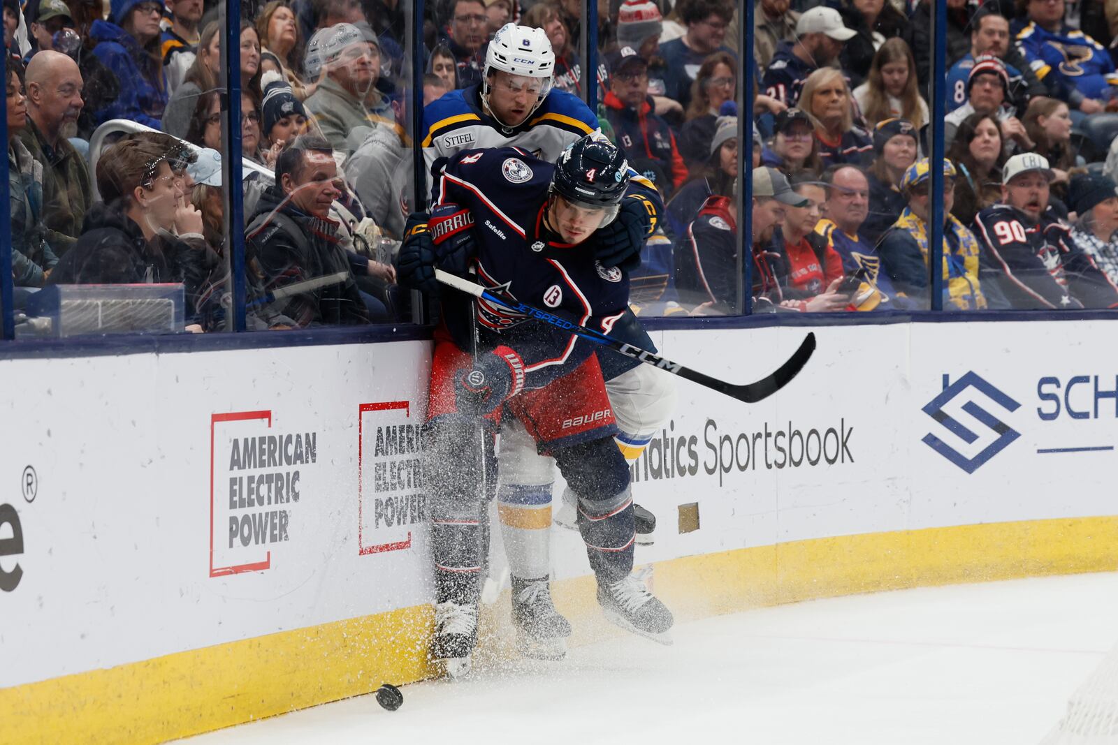 Columbus Blue Jackets' Cole Sillinger, front, keeps the puck away from St. Louis Blues' Philip Broberg during the second period of an NHL hockey game Saturday, Jan. 4, 2025, in Columbus, Ohio. (AP Photo/Jay LaPrete)