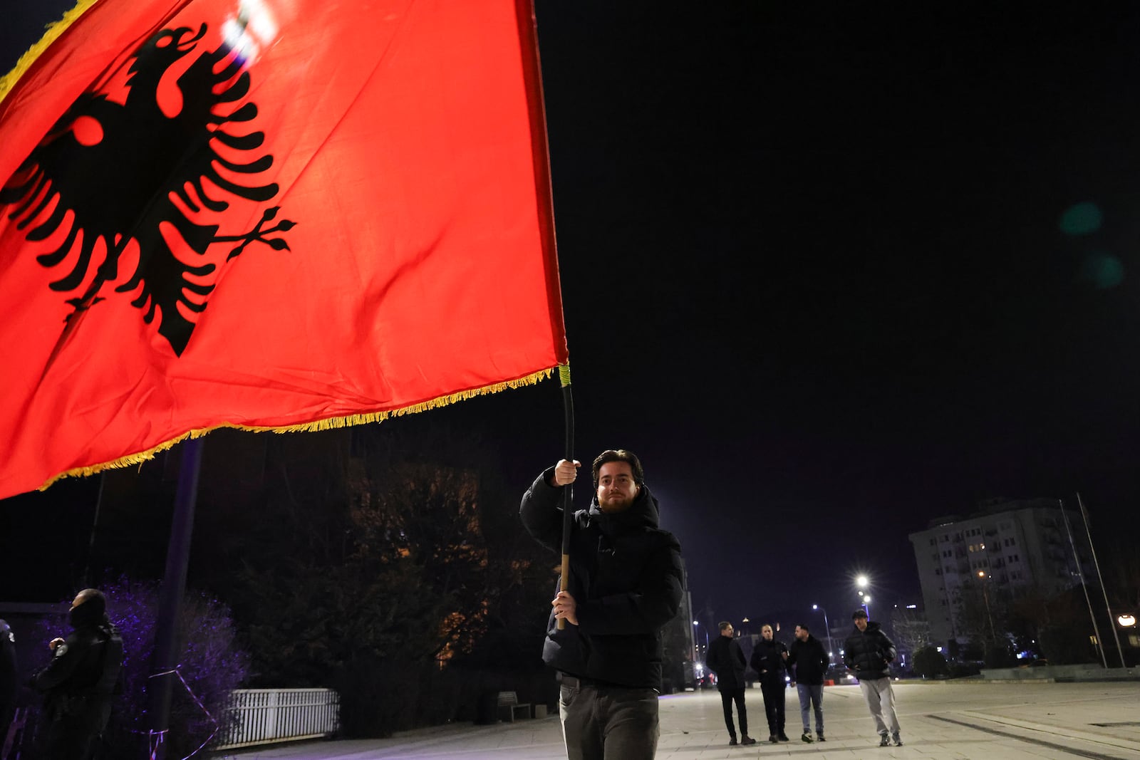 A supporter of left-wing Vetevendosje! party raises an Albanian flag following results of a parliamentary election, in Pristina, Kosovo, Monday, Feb. 10, 2025. (AP Photo/Vlasov Sulaj)