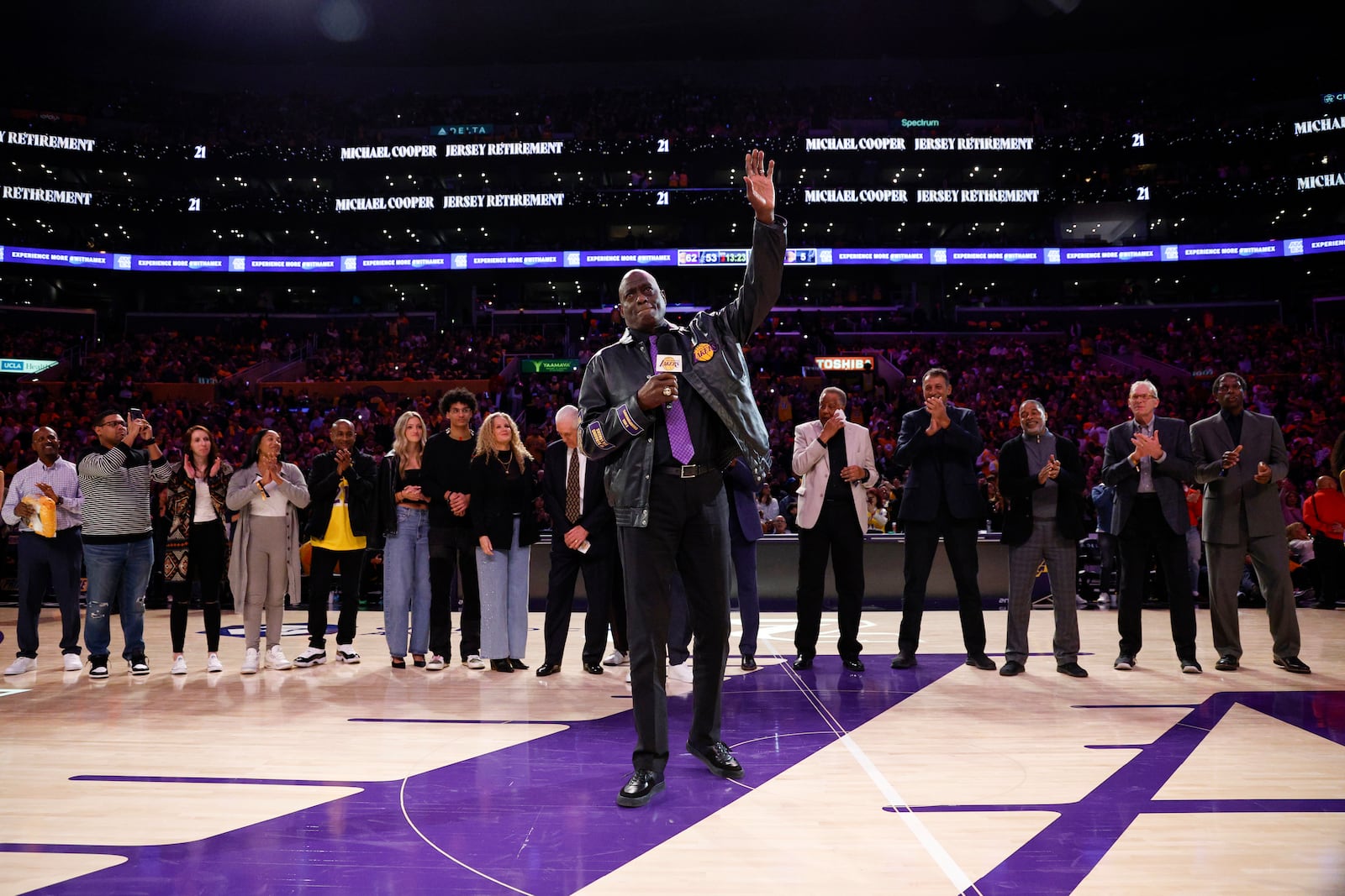 Former Los Angeles Lakers player Michel Cooper, center, waves during his jersey retirement ceremony during halftime in an NBA basketball game between Los Angeles Lakers and the San Antonio Spurs, Monday, Jan. 13, 2025, in Los Angeles. (AP Photo/Kevork Djansezian)