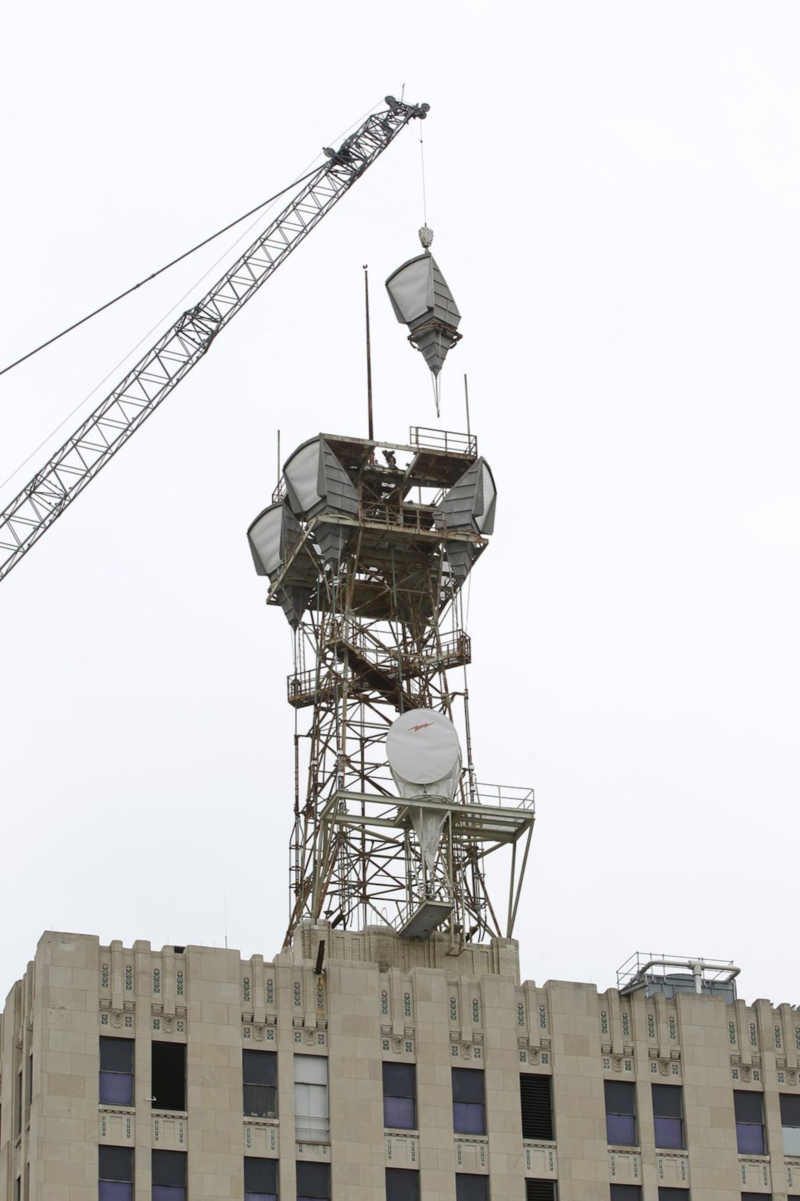 Workers tear down at microwave tower on top of the AT&T building in downtown Dayton. Ty Greenlees