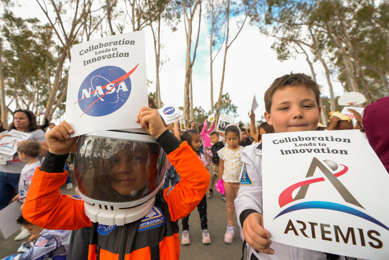 Santiago STEAM Magnet Elementary School students wearing space themed clothing attend a ceremony to plant a small Giant Sequoia tree from NASA's Artemis I Mission's tree seeds that traveled around the moon twice, after the school was honored in the spring of 2024 to become NASA Moon Tree Stewards in Lake Forest, Calif., on Monday, Oct. 14, 2024. (AP Photo/Damian Dovarganes)