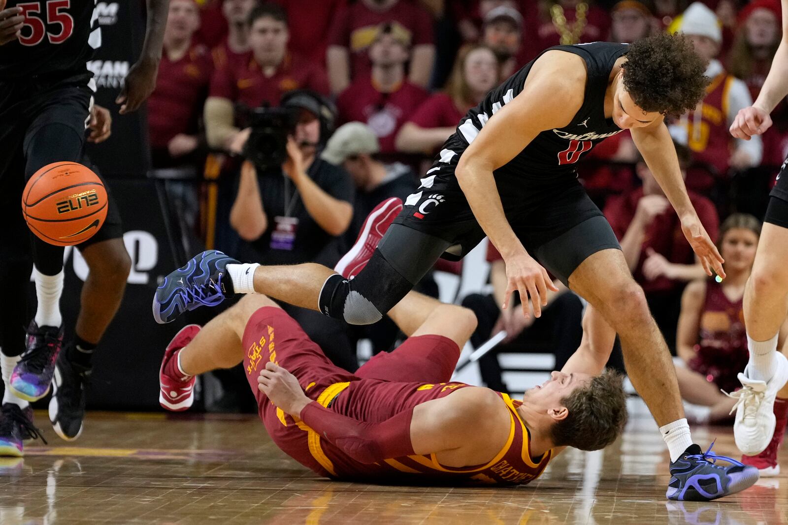 Cincinnati guard Dan Skillings Jr. (0) fights for a loose ball with Iowa State forward Brandton Chatfield (33) during the first half of an NCAA college basketball game Saturday, Feb. 15, 2025, in Ames, Iowa. (AP Photo/Charlie Neibergall)