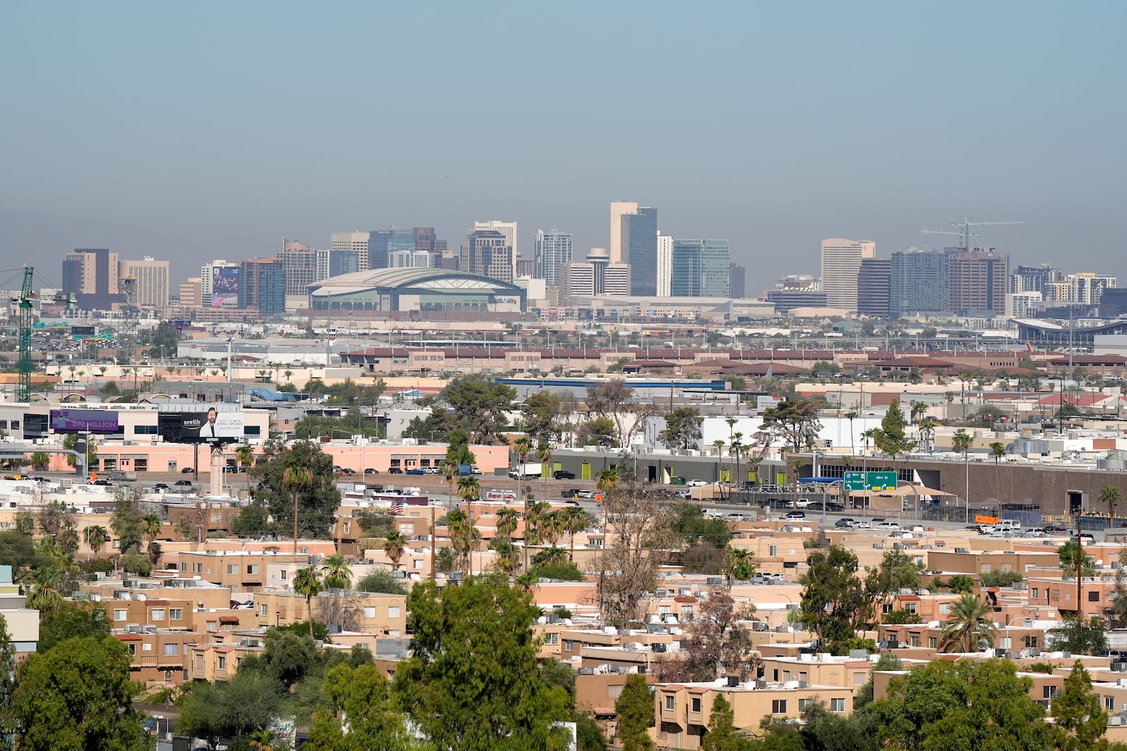 Condos and apartments give way to the Phoenix skyline Tuesday, Sept. 24, 2024, in Tempe, Ariz. (AP Photo/Ross D. Franklin)