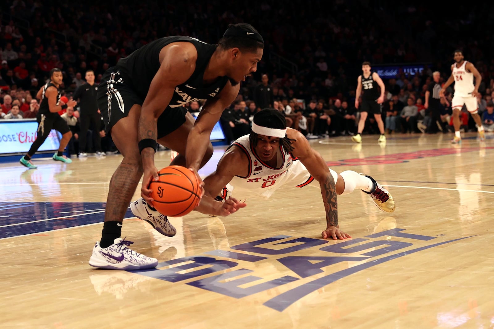 Xavier guard Ryan Conwell, left, and St. John's guard Aaron Scott (0) compete for the ball during the second half of an NCAA college basketball game, Wednesday, Jan. 22, 2025, in New York. (AP Photo/Pamela Smith)