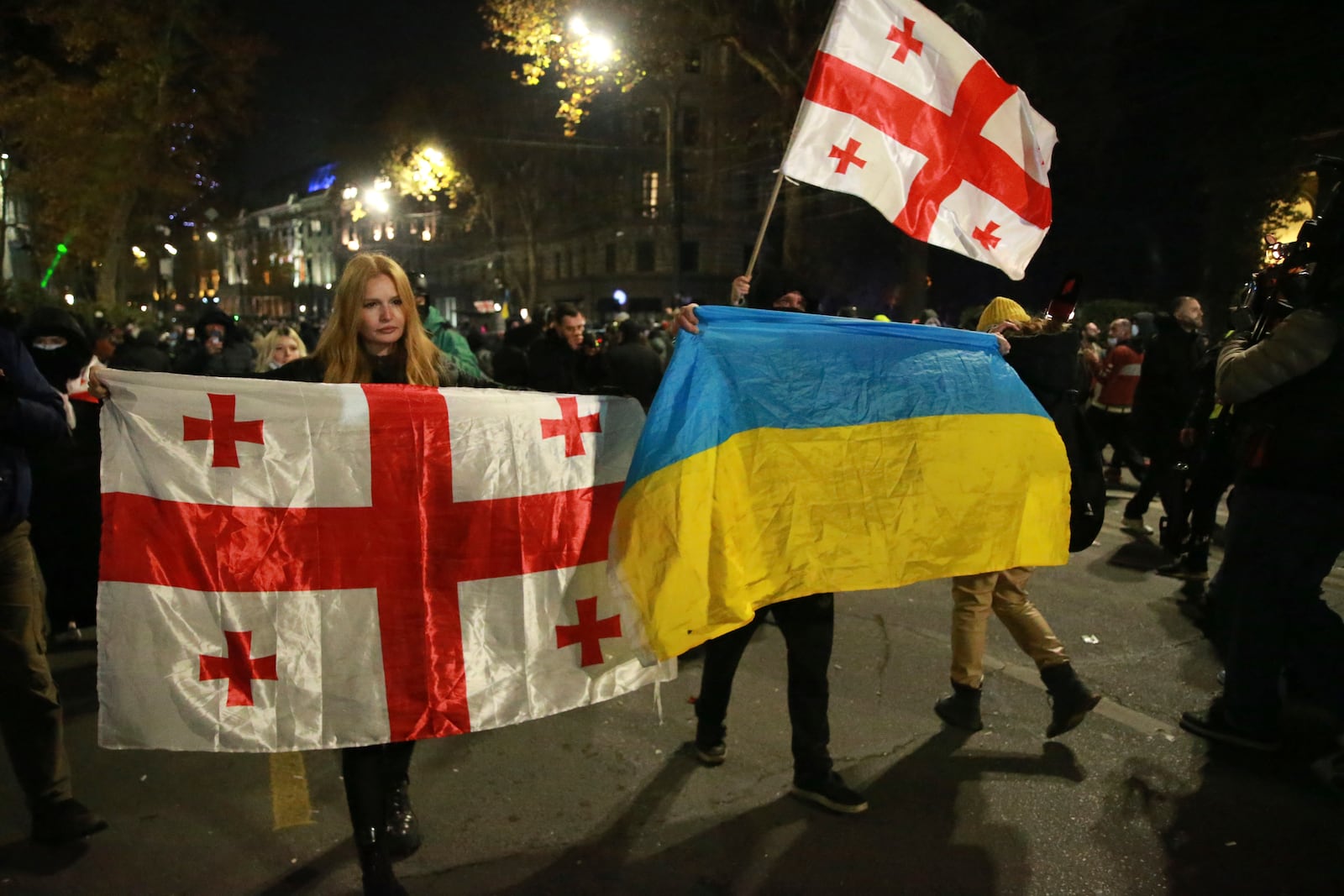 Demonstrators hold Georgian and Ukrainian national flags during a rally to protest against the government's decision to suspend negotiations on joining the European Union in Tbilisi, Georgia, on Tuesday, Dec. 3, 2024. (AP Photo/Zurab Tsertsvadze)