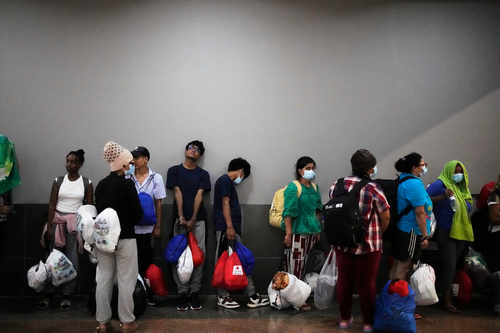 Migrants, mostly from Asian countries, wait for transport to hotels after arriving in Panama City on Saturday, March 8, 2025, after spending weeks in a temporary Panamanian immigration camp following their deportation from the U.S. and being released on the condition they leave the country within 30 days. (AP Photo/Matias Delacroix)