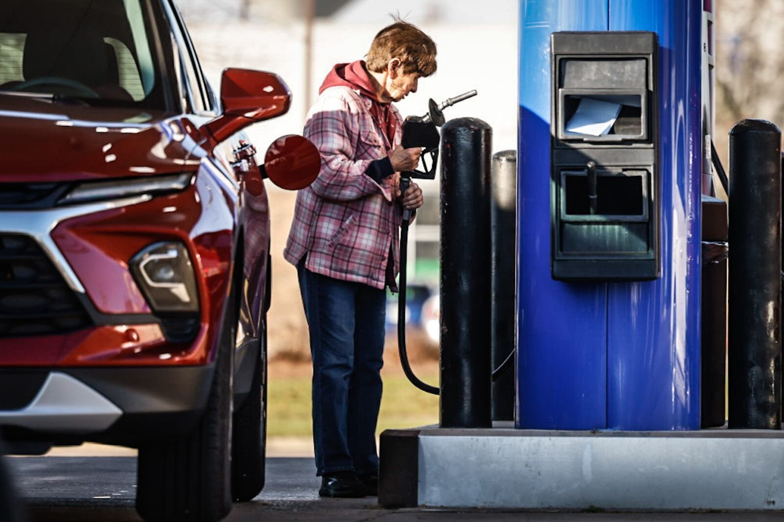 Brenda Boyer, from Farmersville, pumps gas at the Marathon in New Lebanon Friday morning December 8, 2023. Falling gas price for the last 11 consecutive weeks has helped businesses and consumers during these inflationary times. JIM NOELKER/STAFF