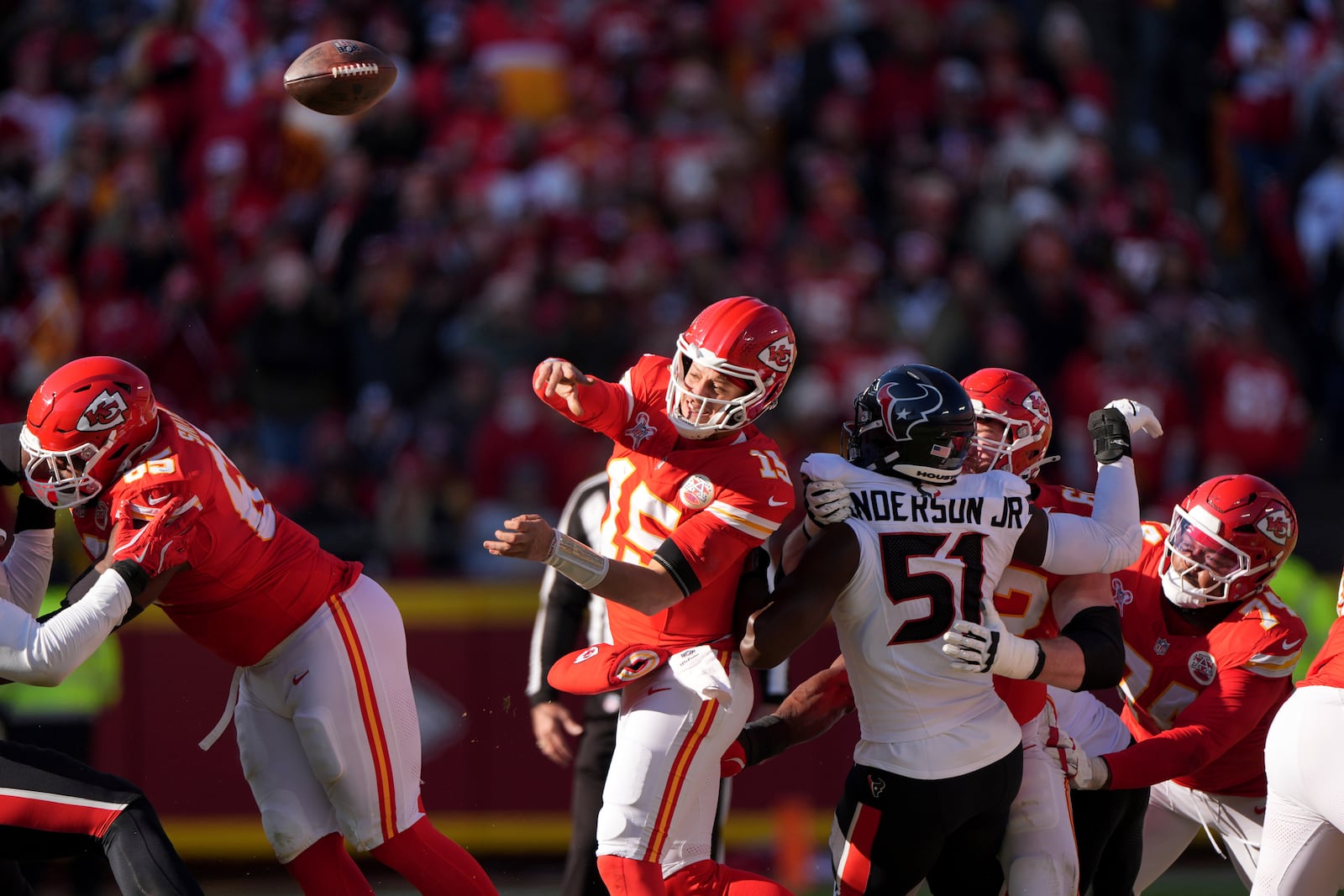 Kansas City Chiefs quarterback Patrick Mahomes (15) throws as Houston Texans defensive end Will Anderson Jr. (51) defends during the first half of an NFL football game Saturday, Dec. 21, 2024, in Kansas City, Mo. (AP Photo/Charlie Riedel)