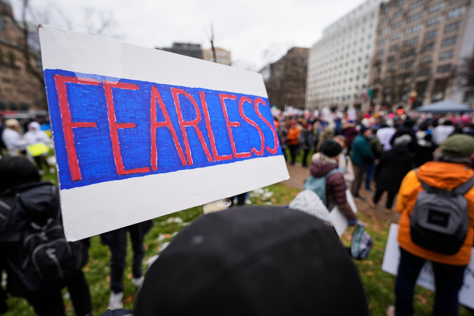 A person holds a sign reading, "Fearless," in Farragut Square before the start of the People's March, Saturday, Jan. 18, 2025, in Washington. (AP Photo/Mike Stewart)