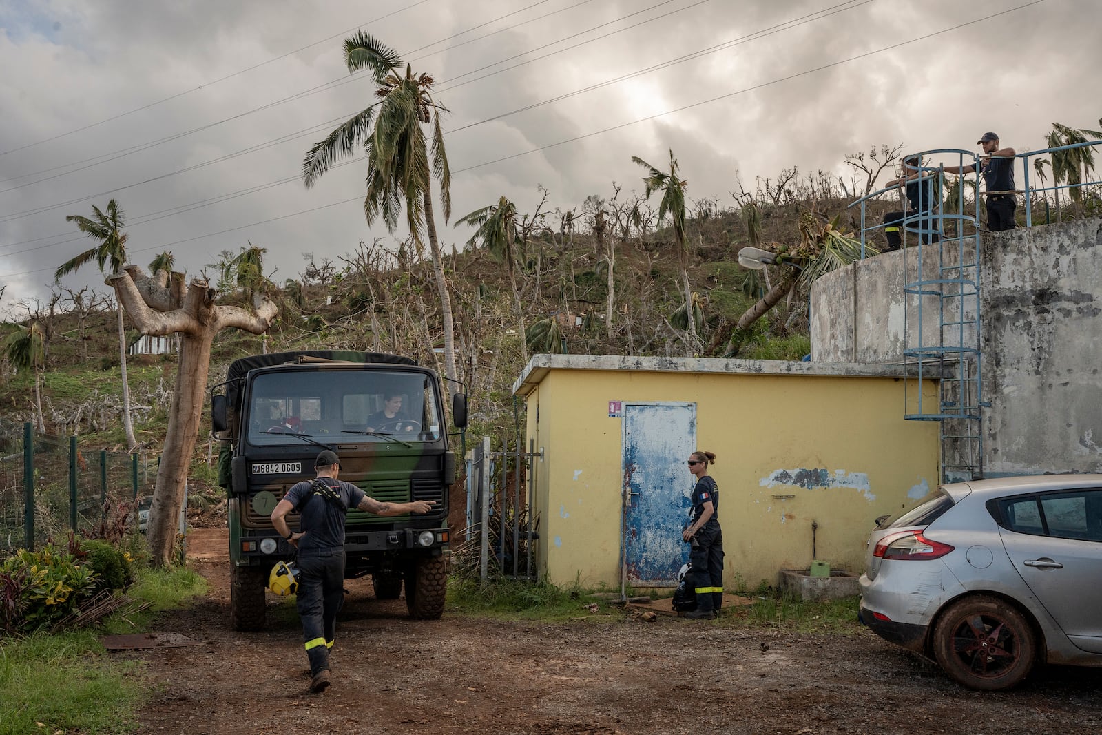 French civil security officers reach the water station in Mirereni, Mayotte, Friday, Dec. 20, 2024. (AP Photo/Adrienne Surprenant)