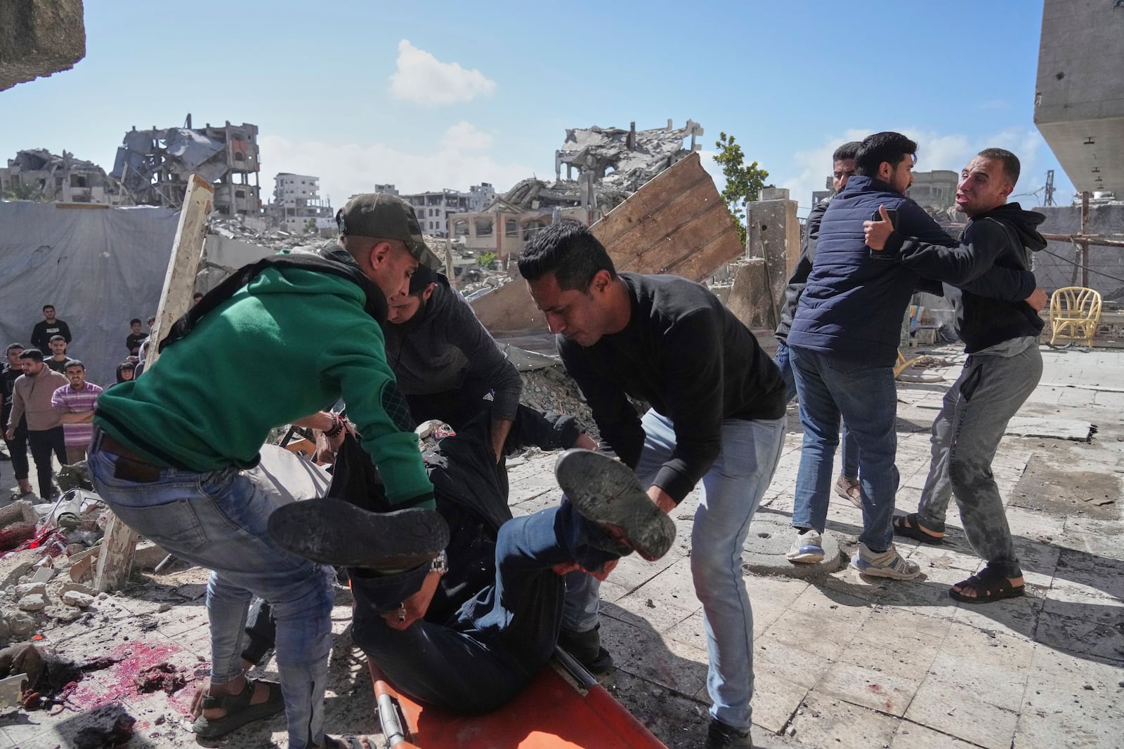 Palestinians evacuate an injured man after his house was hit by an Israeli bombardment in Gaza City, Wednesday, March 19, 2025. (AP Photo/Jehad Alshrafi)