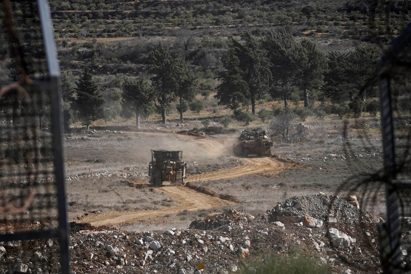 Israeli armoured vehicles cross the security fence moving towards the so-called Alpha Line that separates the Israeli-controlled Golan Heights from Syria, in the town of Majdal Shams, Friday, Dec. 13, 2024. (AP Photo/Matias Delacroix)