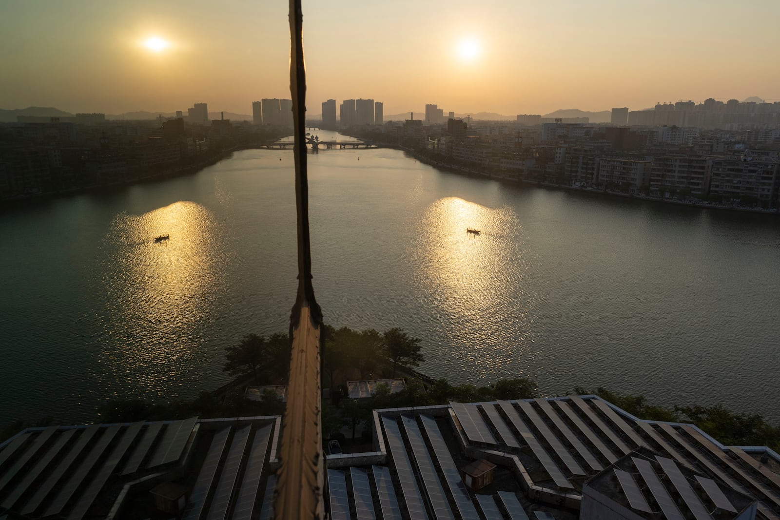 Solar panels on a roof are seen near the sunrise over Jiangmen in southern China's Guangdong province on Friday, Oct. 11, 2024. (AP Photo/Ng Han Guan)