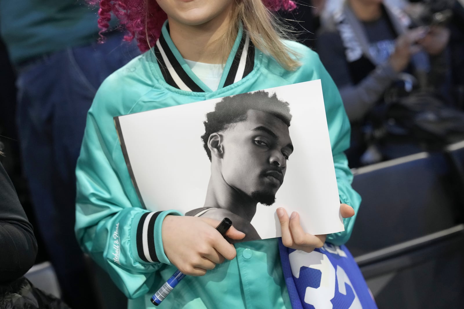 A fan holds up photo of San Antonio Spurs center Victor Wembanyama before a Paris Games 2025 NBA basketball game between the Indiana Pacers and the Spurs in Paris, Thursday, Jan. 23, 2025. (AP Photo/Thibault Camus)