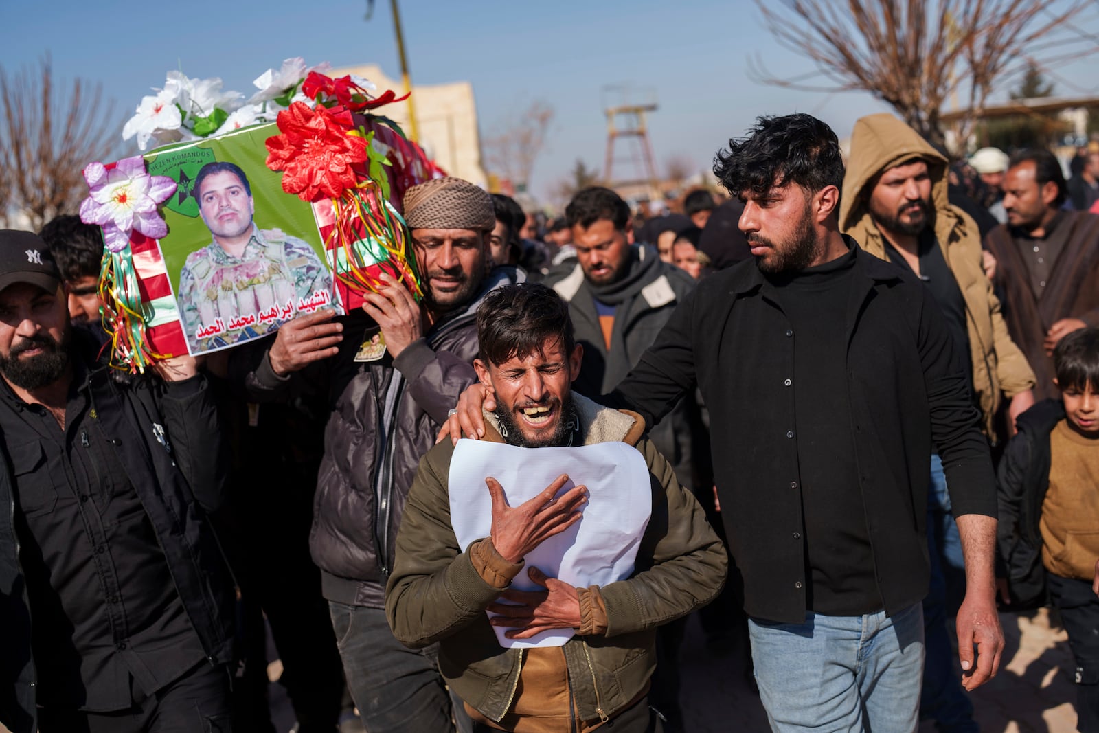 FILE - Men carry the coffin of Ibrahim al-Hamad, who was killed by a Turkish-backed militia, during the funeral of four Syrian Democratic Forces fighters in the village of Daoudiya in northeastern Syria's Hassakeh province, Wednesday, Jan. 29, 2025. (AP Photo/Bernat Armangue, File)