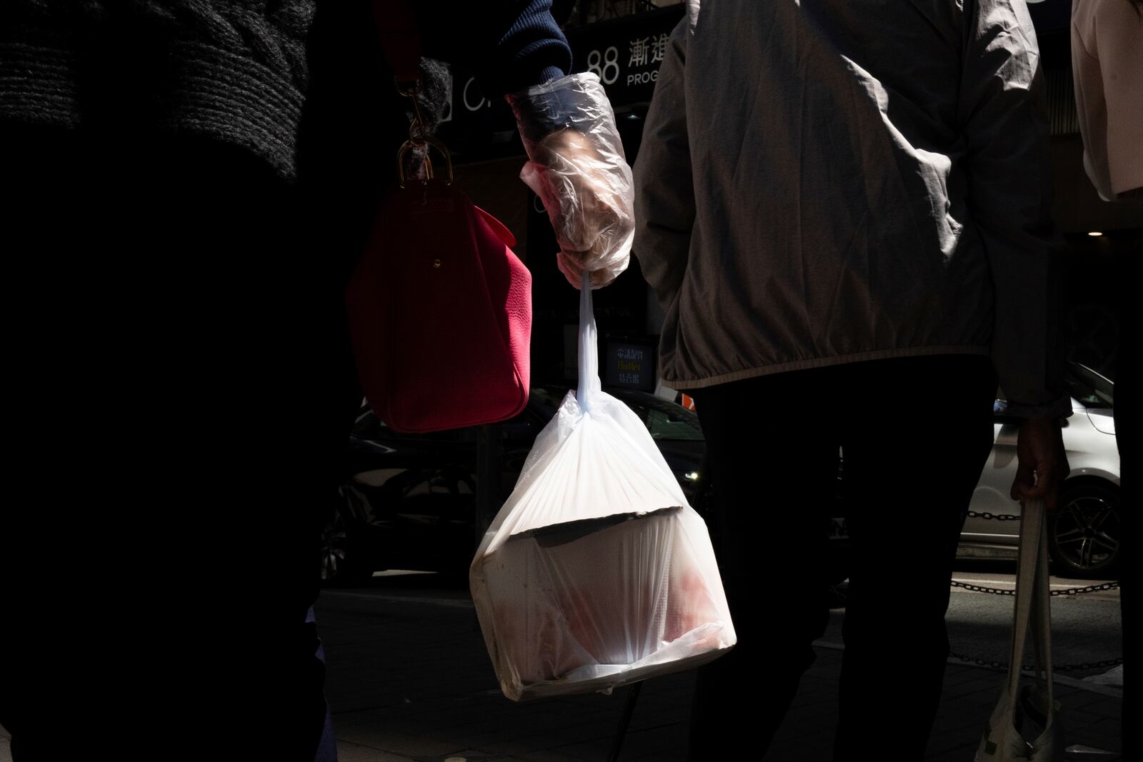 FILE - A pedestrian carries takeaway food in a plastic bag in Hong Kong, March 13, 2024.(AP Photo/Louise Delmotte, File)