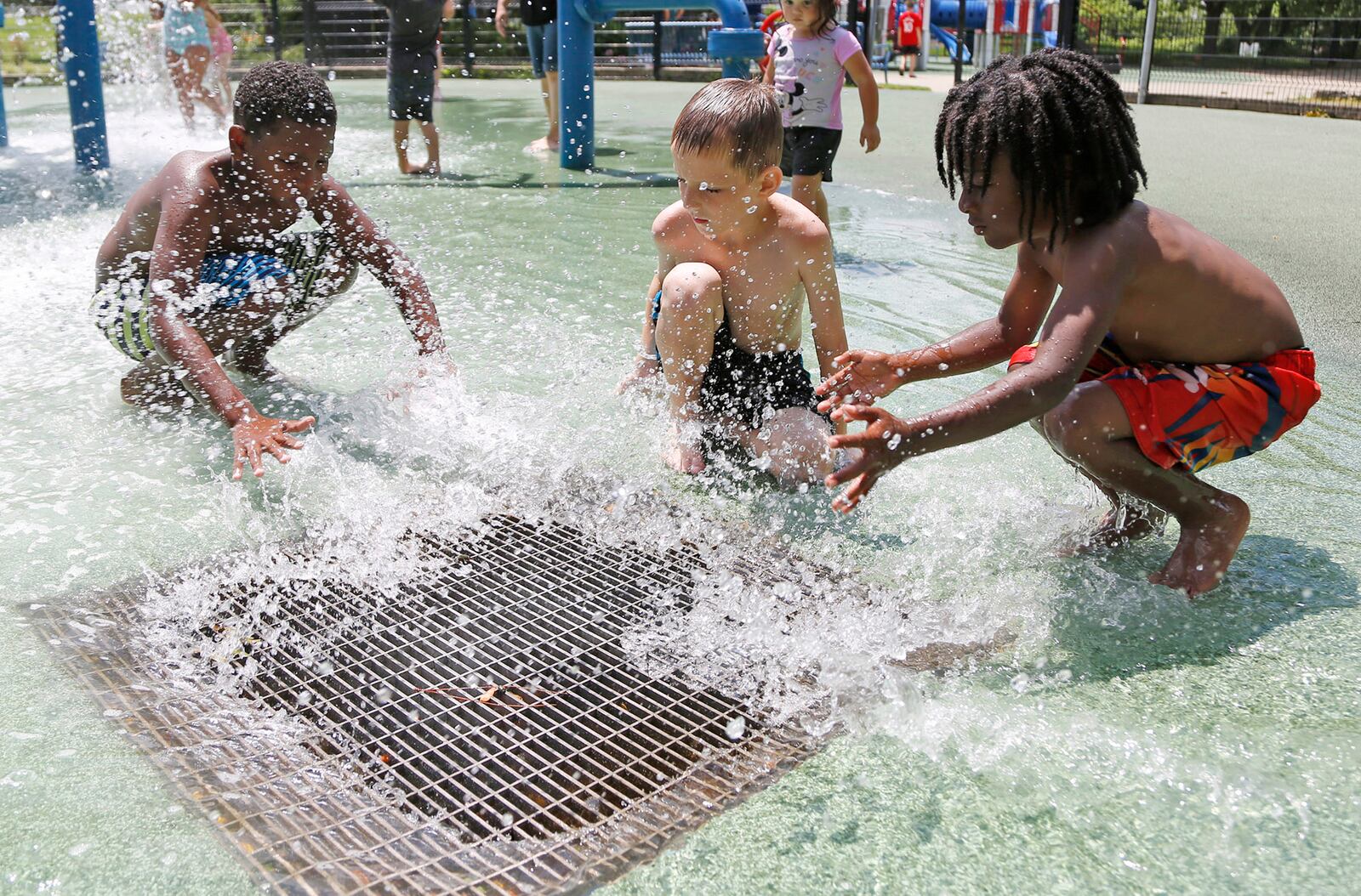 Boys splash a beetle that landed on the spalsh pad water drain at the Island Park on Thursday. A high heat index is expected to last through Satruday, making work outdoors potentially dangerous for those not acclimated to it.  TY GREENLEES / STAFF