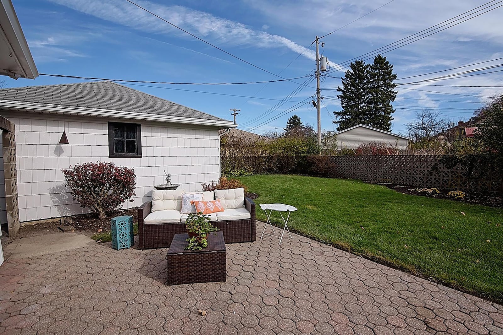 The rear of the home has a family room addition, a two-car detached garage and a paver patio. The yard is surrounded with a wood privacy fence. CONTRIBUTED