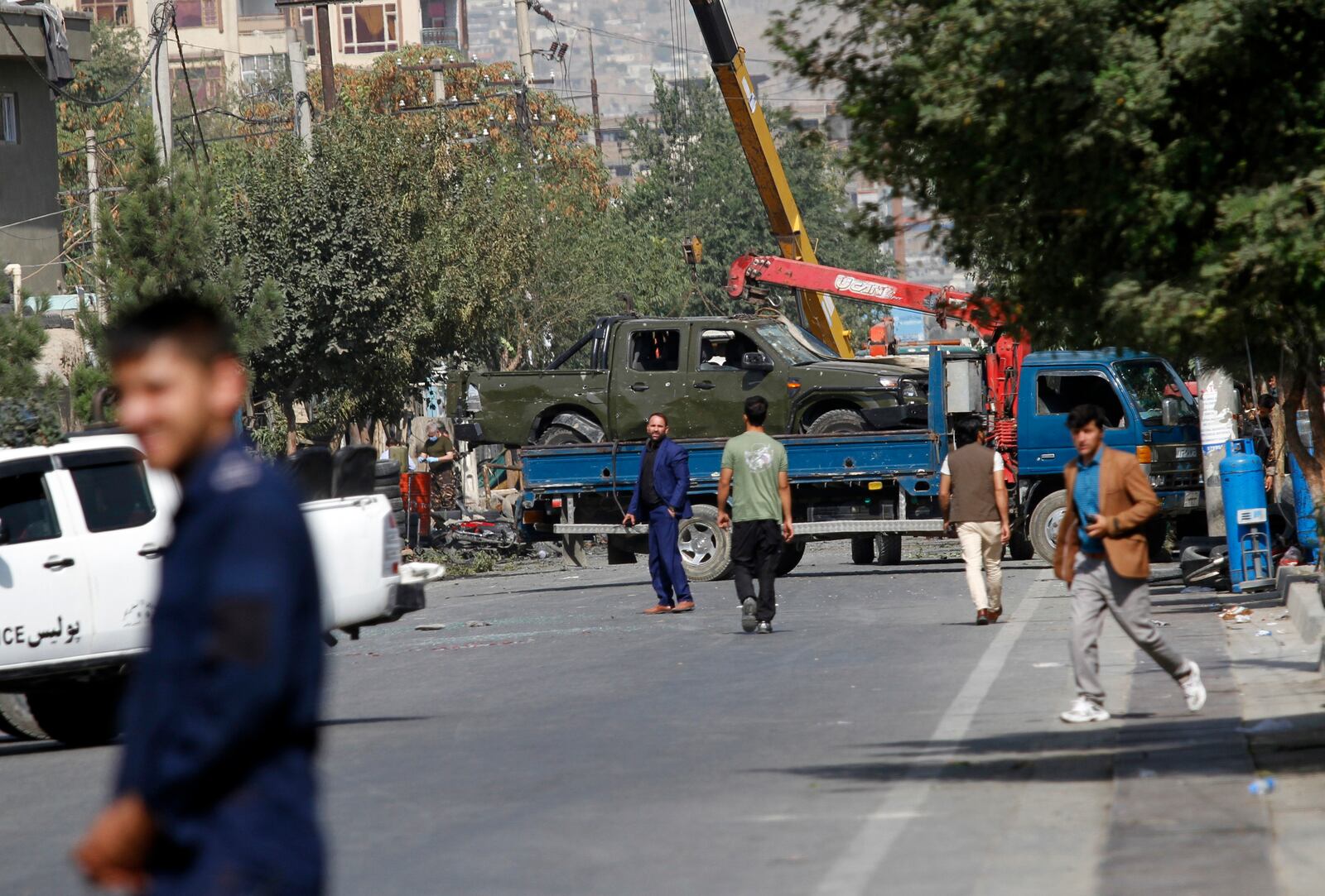 Afghan security personnel move a damaged vehicle belonging to a vice president convoy targeted by an explosion in Kabul, Afghanistan, Wednesday, Sept. 9, 2020. (AP Photo/Rahmat Gul)