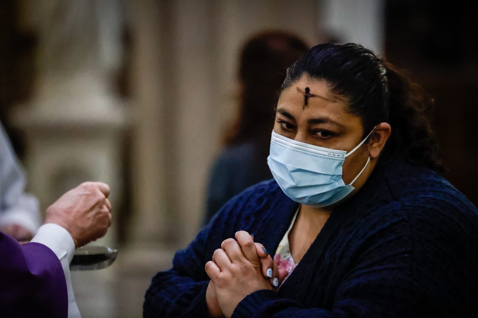 St. Mary Catholic Church parishioner Imelda Ayala receives Ash Wednesday ashes from the Rev. Anthony Geraci at the church in Dayton. Ash Wednesday marks the beginning of Lent for Christians. JIM NOELKER/STAFF