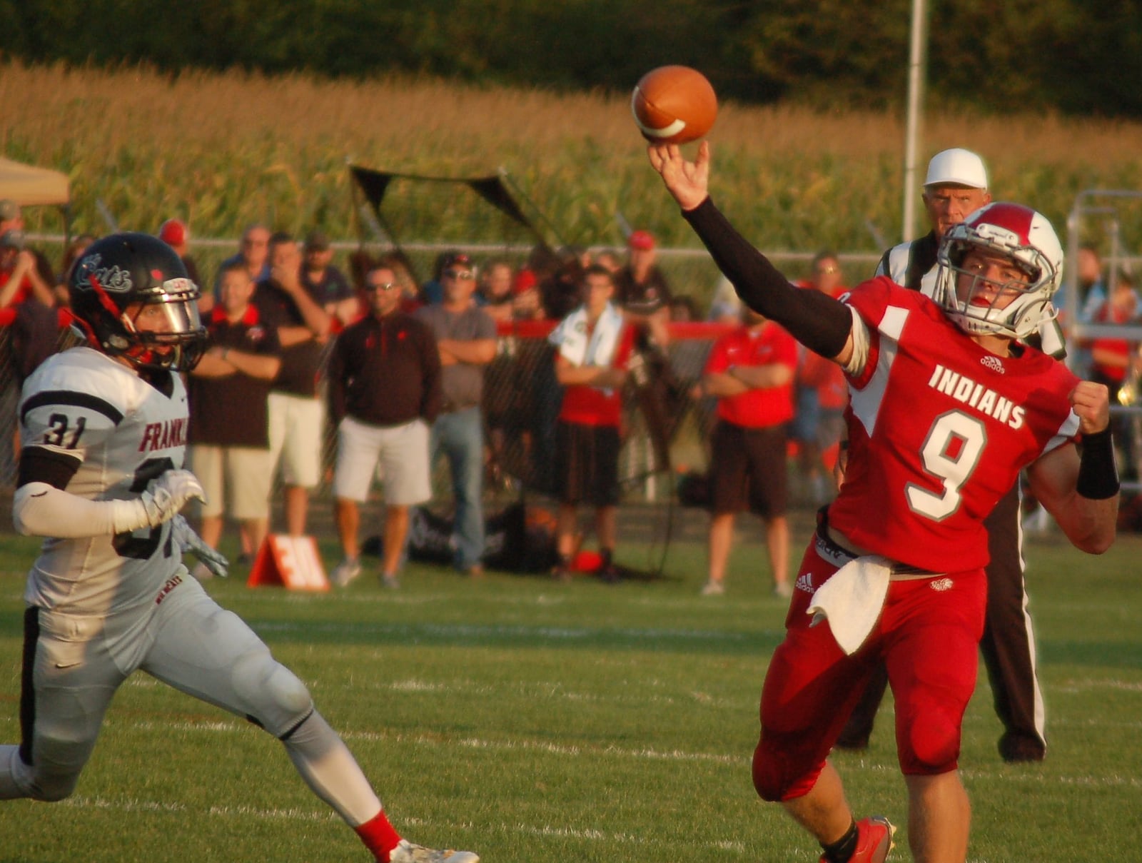 Carlisle quarterback Jake Moore delivers a pass as Franklin’s Carson Bowling pursues Friday night at Laughlin Field in Carlisle. The host Indians dropped a 47-14 decision. CONTRIBUTED PHOTO BY JOHN CUMMINGS