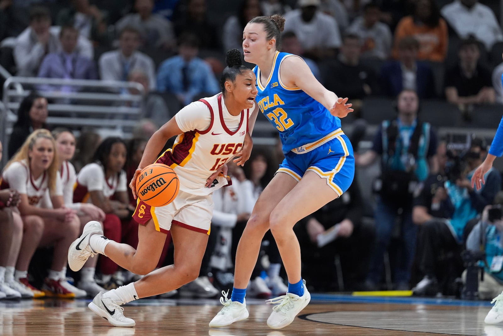 Southern California guard JuJu Watkins (12) drives on UCLA forward Angela Dugalic (32) during the second half of an NCAA college basketball game in the championship of the Big Ten Conference tournament in Indianapolis, Sunday, March 9, 2025. (AP Photo/Michael Conroy)